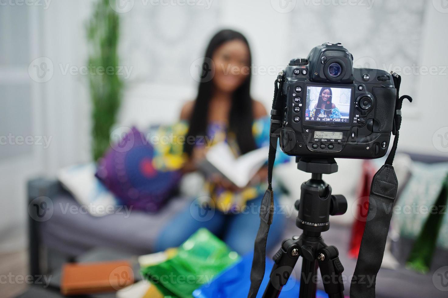 carina donna afroamericana che realizza un video per il suo blog utilizzando una fotocamera digitale montata su treppiede. giovane blogger o vlogger sulla fotocamera. foto