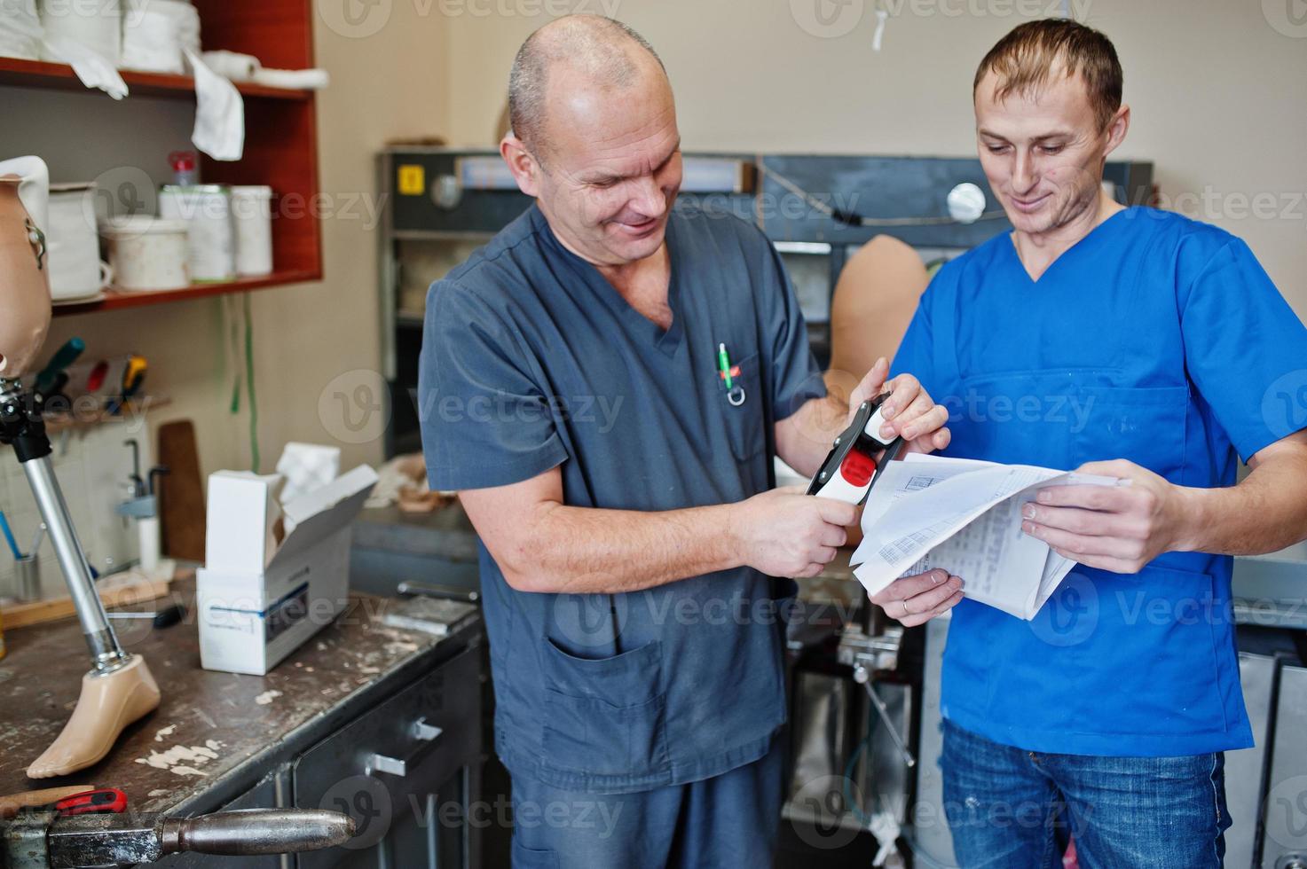 due operai protesisti che realizzano protesi di gamba mentre lavorano in laboratorio. foto