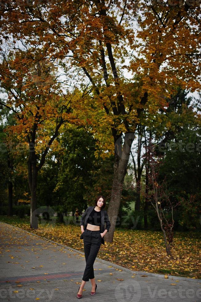 una giovane donna modello bella ed elegante dalle gambe alte in abbigliamento formale poste sullo sfondo autunnale. foto