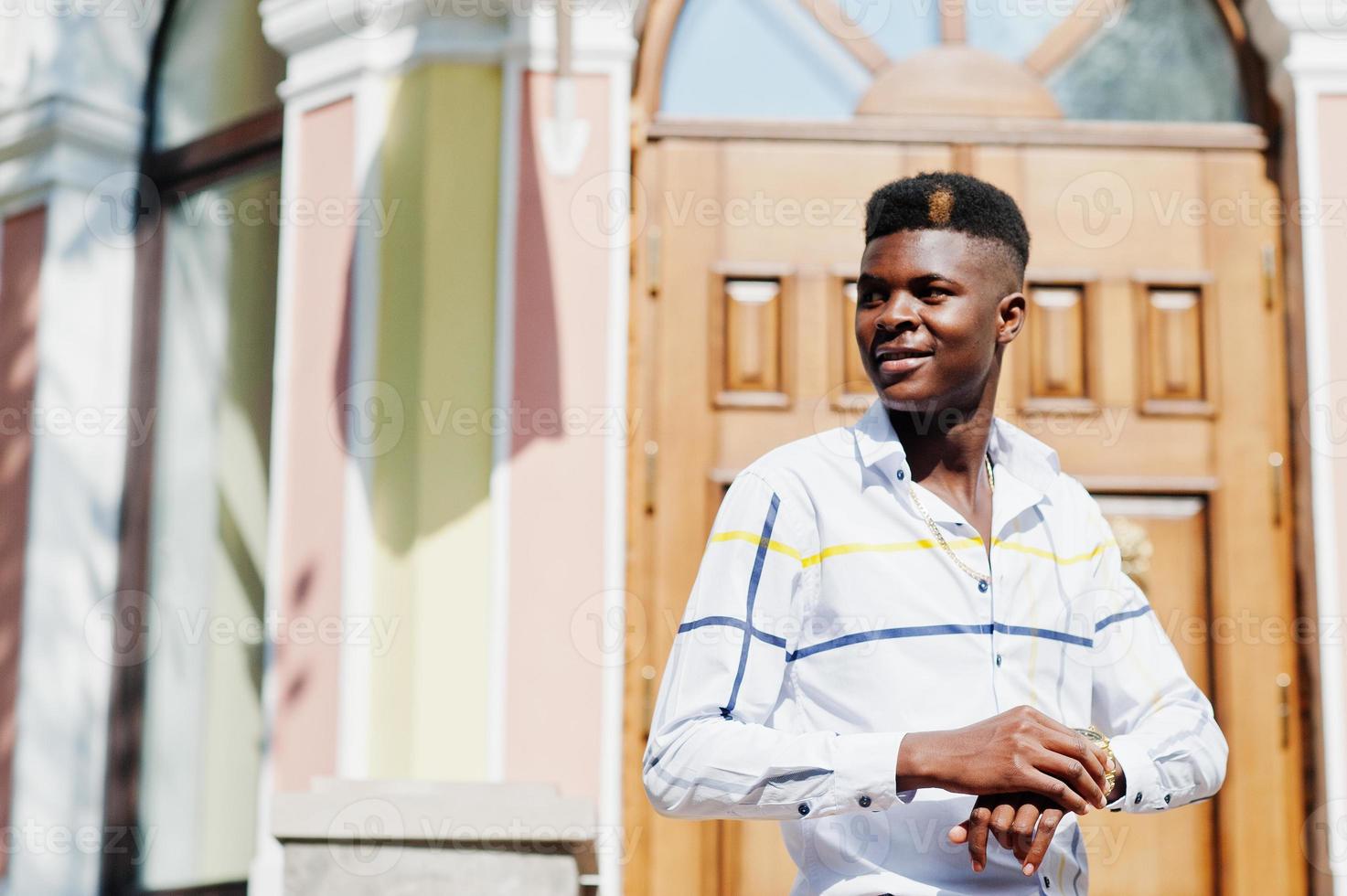 ritratto di uomo bello ed elegante modello afroamericano in pantaloni rossi e camicia bianca. foto