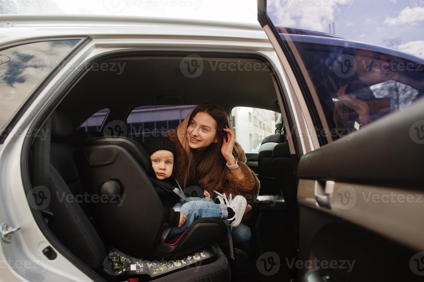 giovane madre e bambino in auto. seggiolino per bambini sulla sedia. concetto di guida di sicurezza. foto