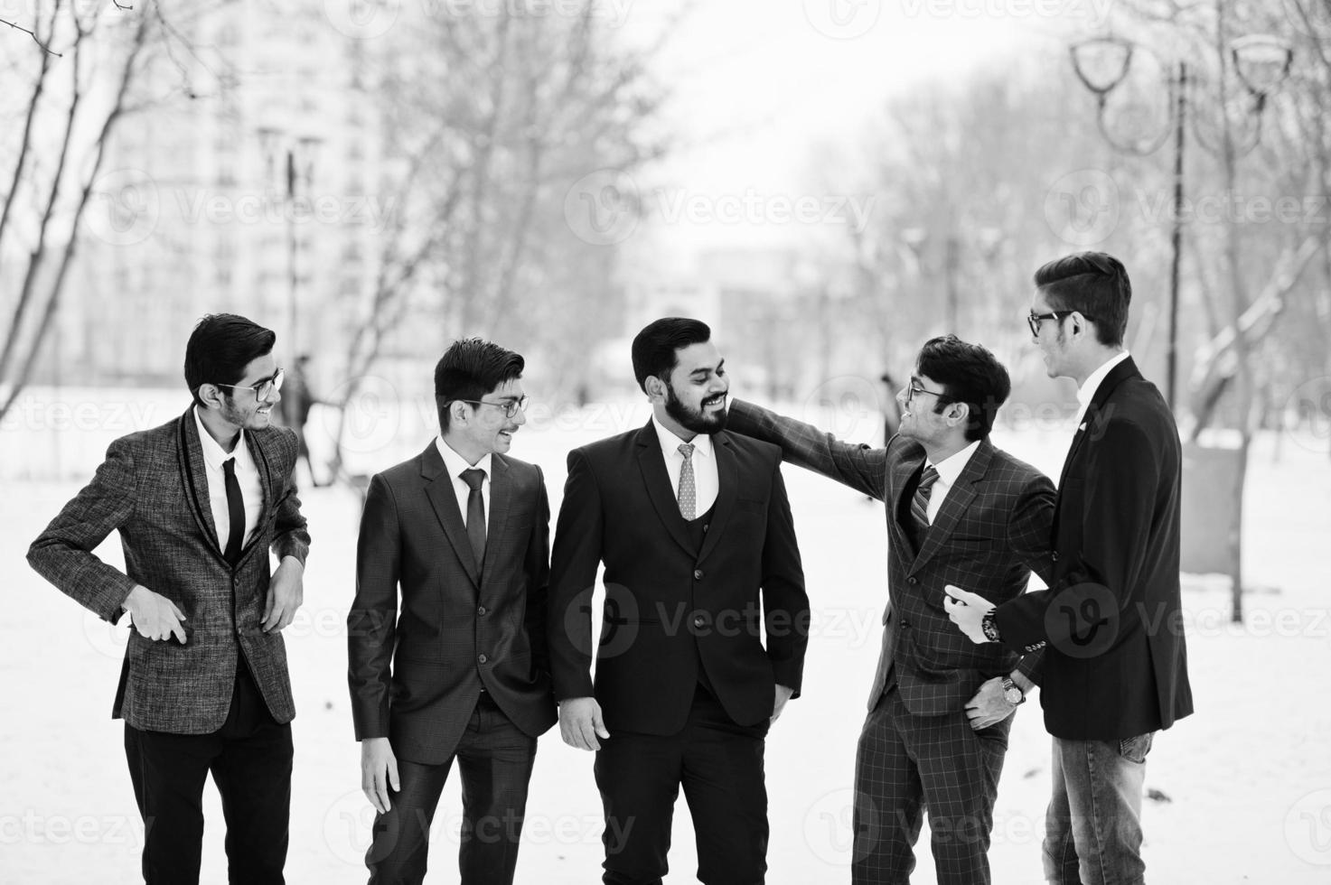 un gruppo di cinque uomini d'affari indiani in giacca e cravatta hanno posato all'aperto e hanno condotto una discussione nella giornata invernale in Europa. foto
