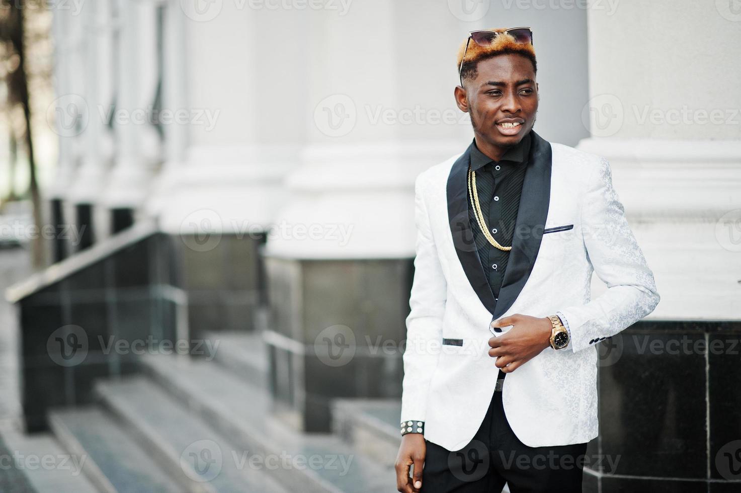 elegante uomo afroamericano bello in abito bianco e occhiali da sole. foto