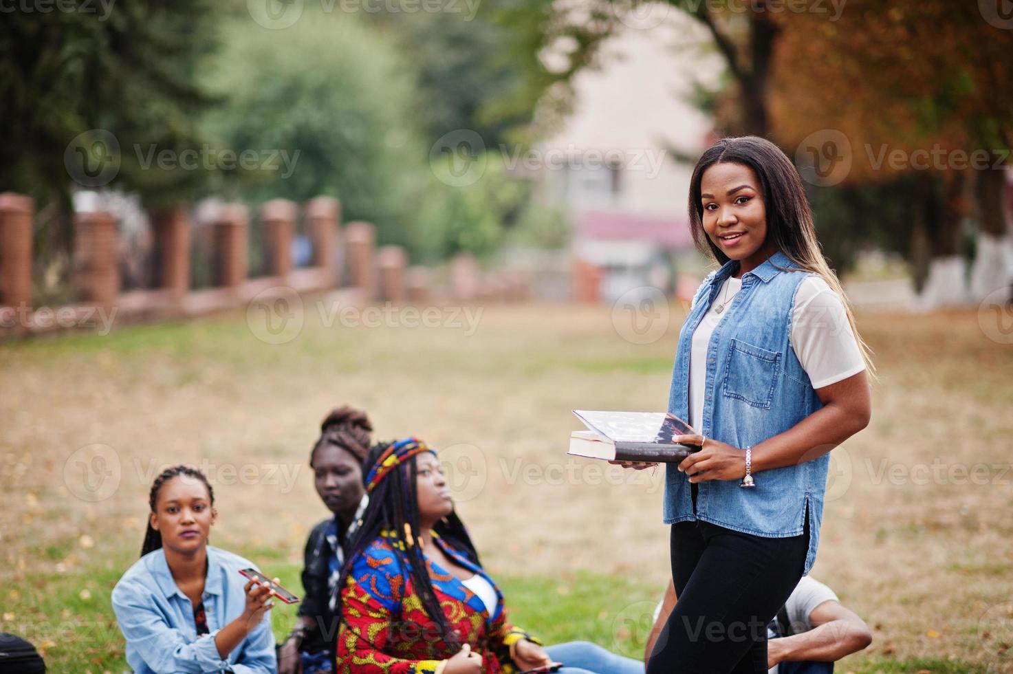 gruppo di cinque studenti universitari africani che trascorrono del tempo insieme nel campus nel cortile dell'università. amici afro neri che studiano. tema dell'educazione. foto