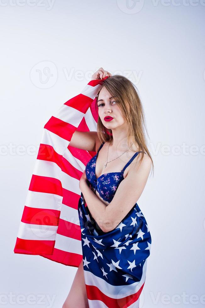 ragazza carina in reggiseno e pantaloncini con bandiera americana degli Stati Uniti isolata su sfondo bianco. foto