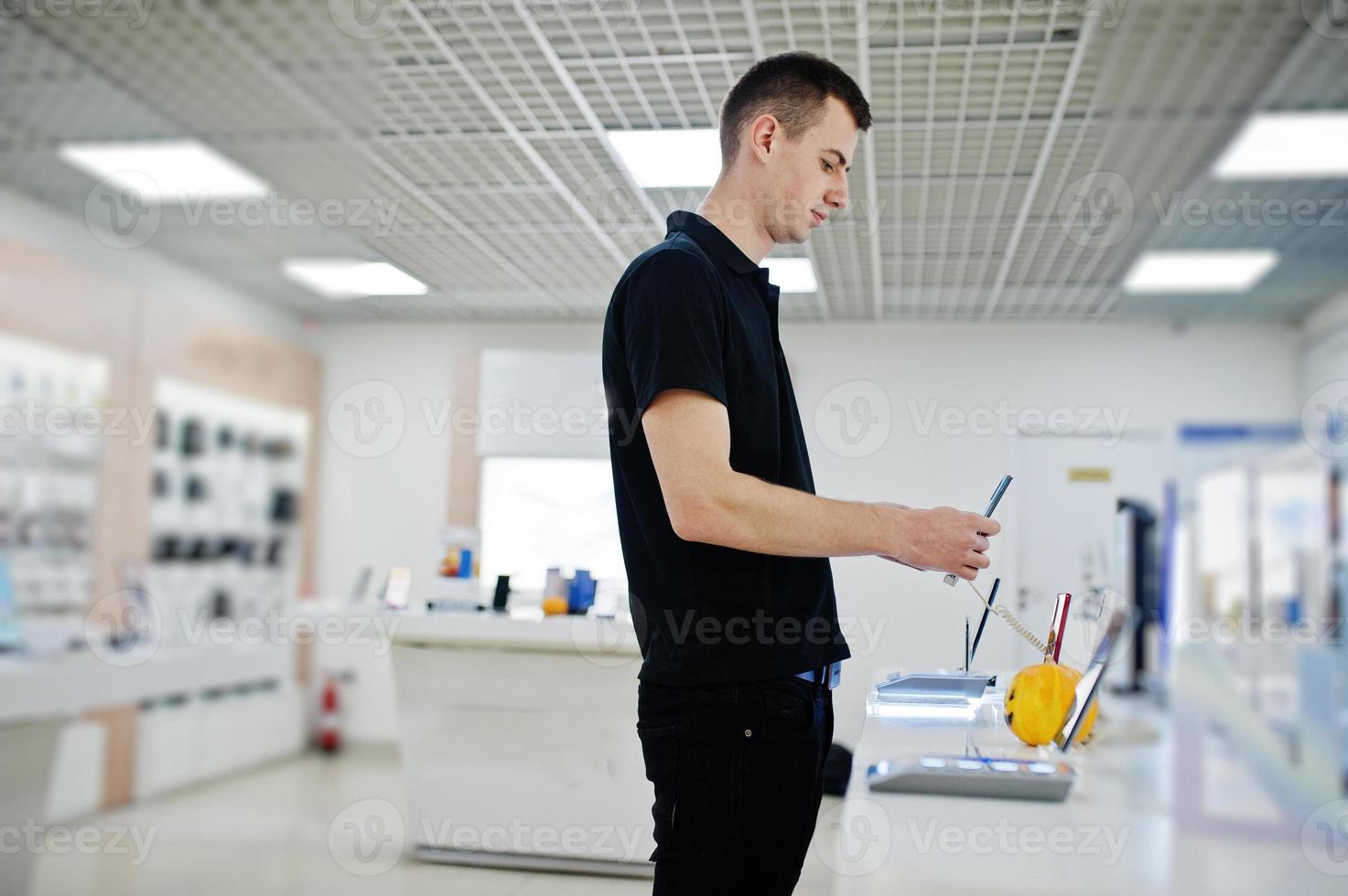 venditore uomo consulente professionale di telefonia mobile in negozio di tecnologia o negozio tenere il nuovo smartphone a portata di mano. foto