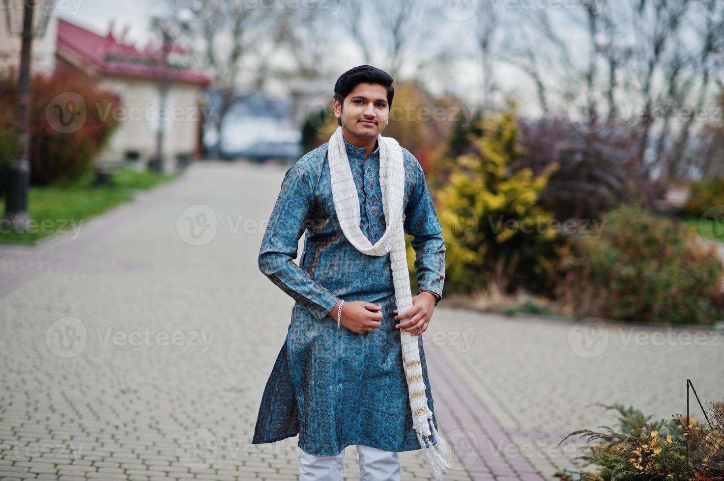 l'uomo indiano indossa abiti tradizionali con sciarpa bianca posata all'aperto. foto