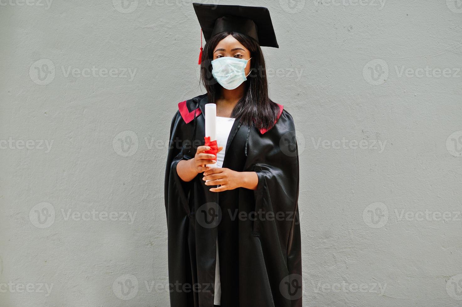 la giovane studentessa laureata afroamericana indossa una maschera protettiva contro il coronavirus. concetto di cerimonia di laurea, quarantena. foto