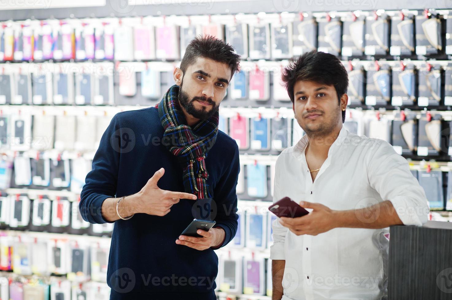 due indiani mans cliente acquirente al negozio di telefoni cellulari con loro nuovi smartphone. concetto di popoli e tecnologie dell'Asia meridionale. negozio di cellulari. foto