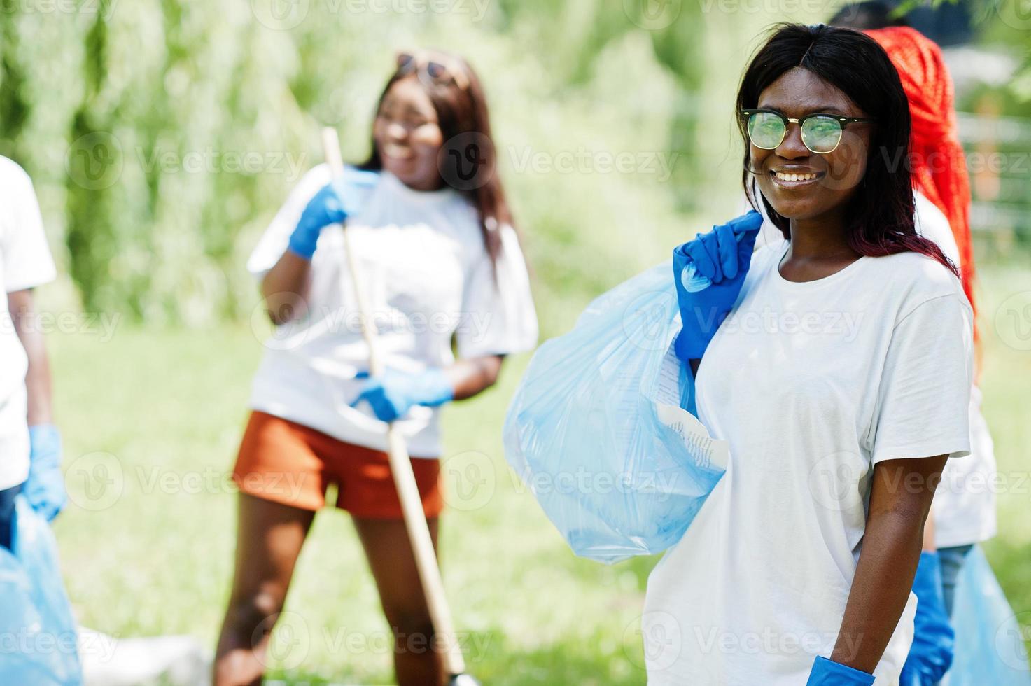 gruppo di volontari africani felici con l'area di pulizia dei sacchi della spazzatura nel parco. concetto di volontariato, carità, persone ed ecologia in africa. foto