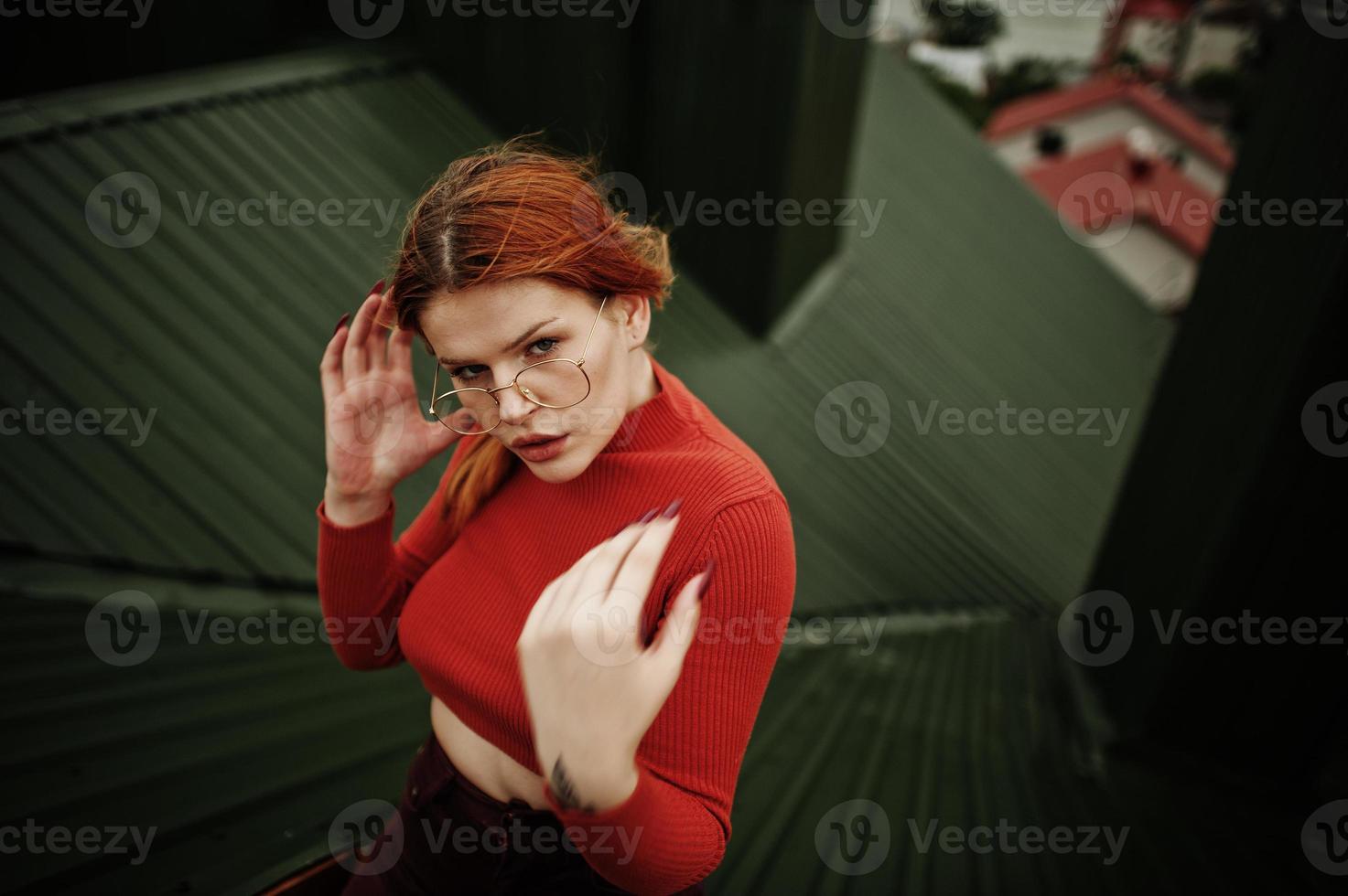 ritratto di moda di ragazza sexy dai capelli rossi sul tetto. modello attraente seduzione donna. foto