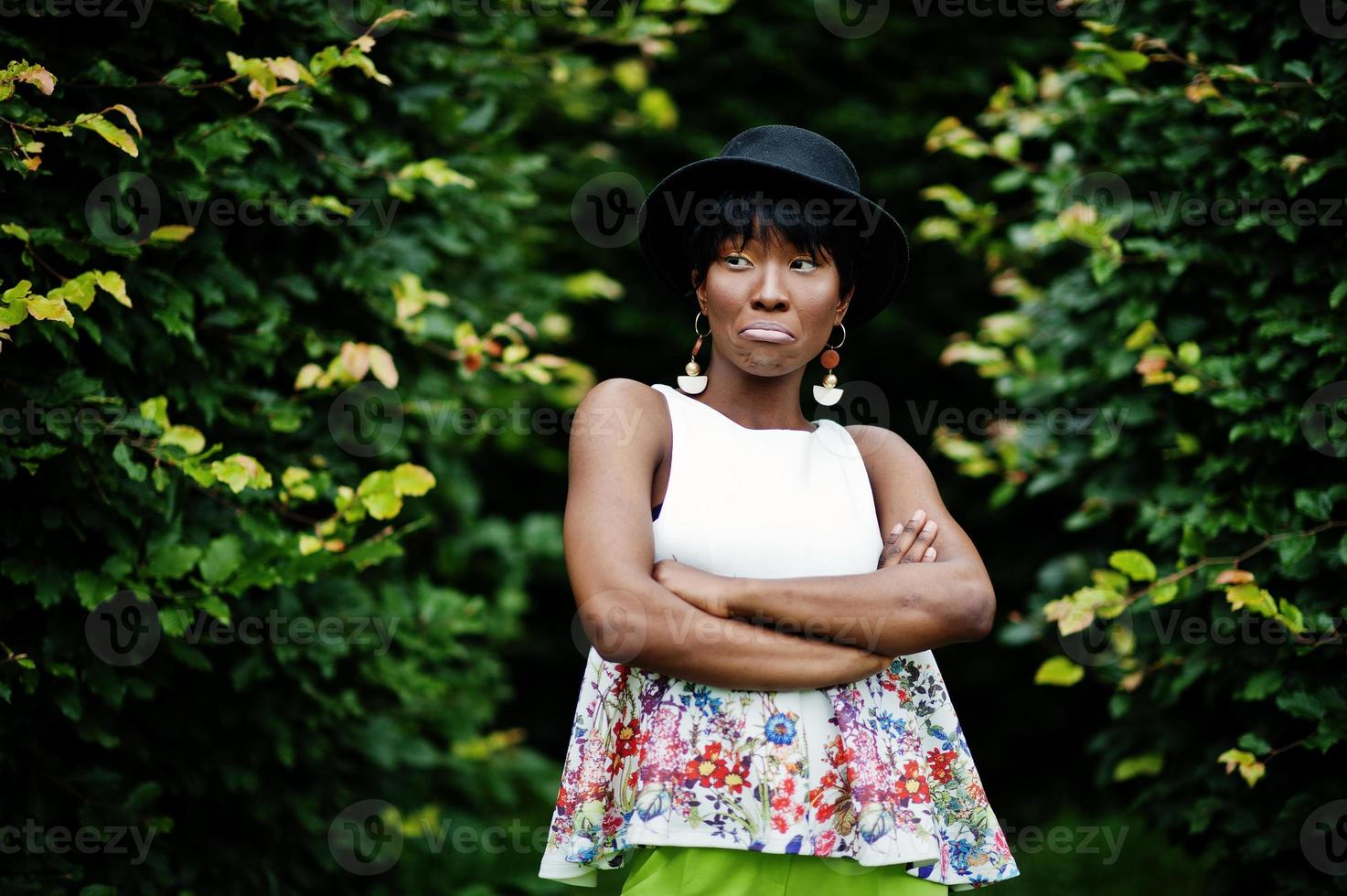 incredibile modella afroamericana in pantaloni verdi e cappello nero in posa con diverse emozioni al parco, mostra la faccia triste. foto