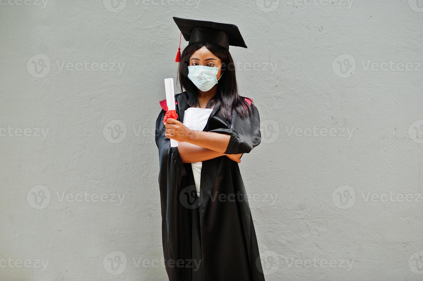 la giovane studentessa laureata afroamericana indossa una maschera protettiva contro il coronavirus. concetto di cerimonia di laurea, quarantena. foto