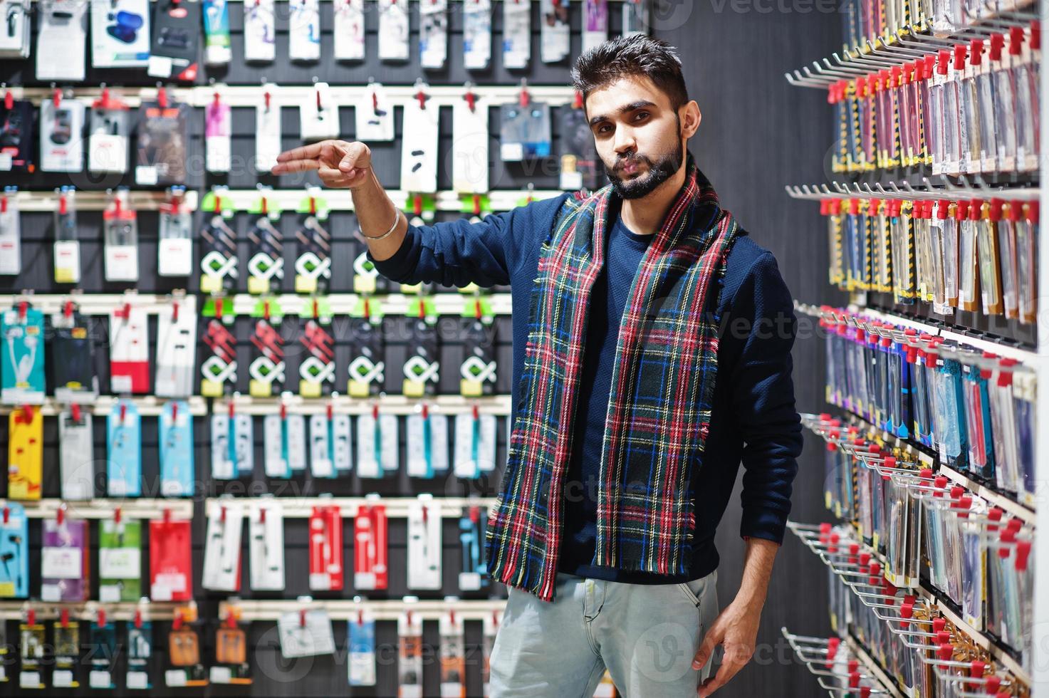 l'acquirente del cliente uomo indiano presso il negozio di telefoni cellulari sceglie una custodia per il suo smartphone. concetto di popoli e tecnologie dell'Asia meridionale. negozio di cellulari. foto