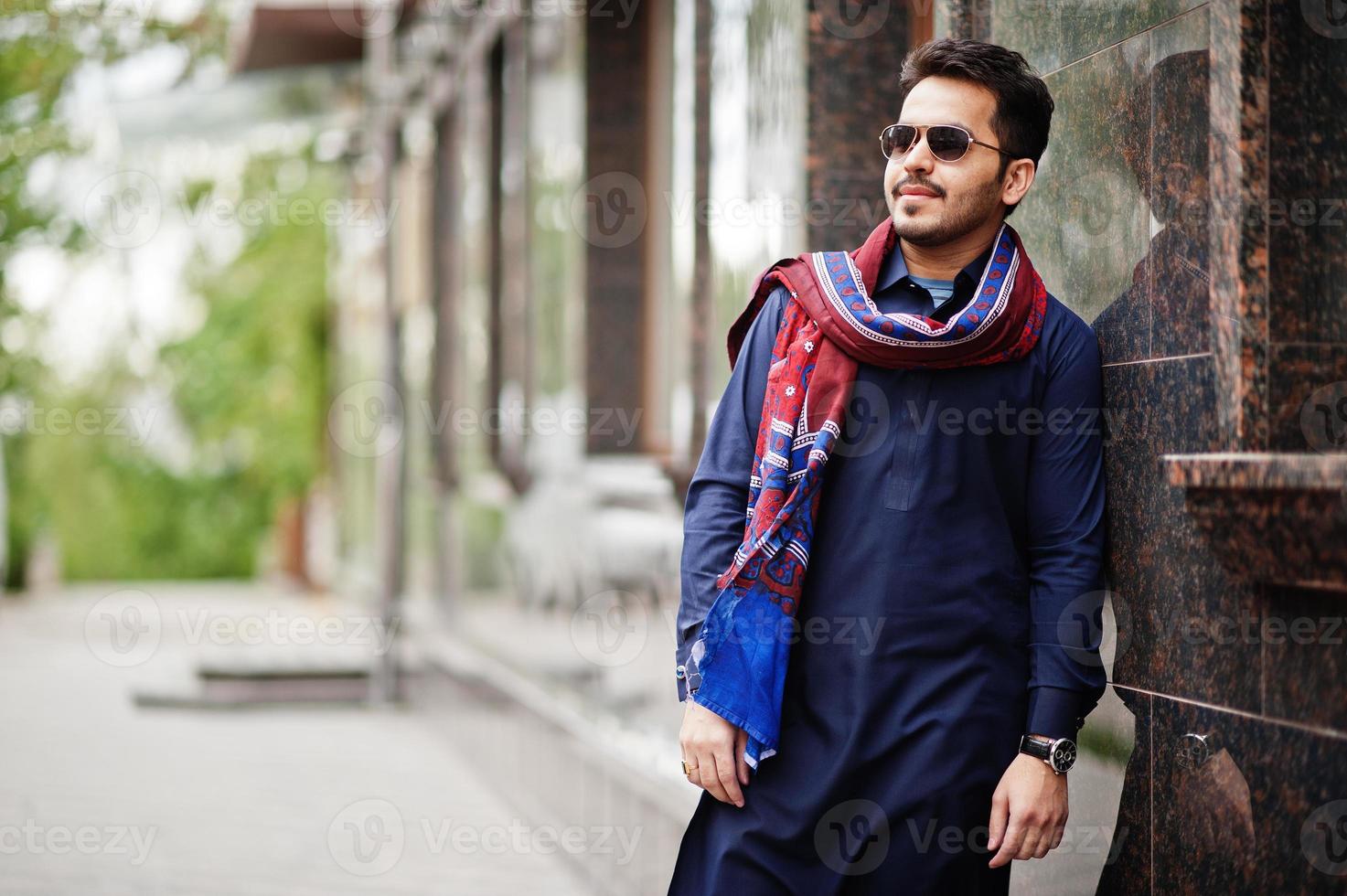 elegante uomo arabo musulmano indiano pakistano in abito kurta dhoti e occhiali da sole. foto