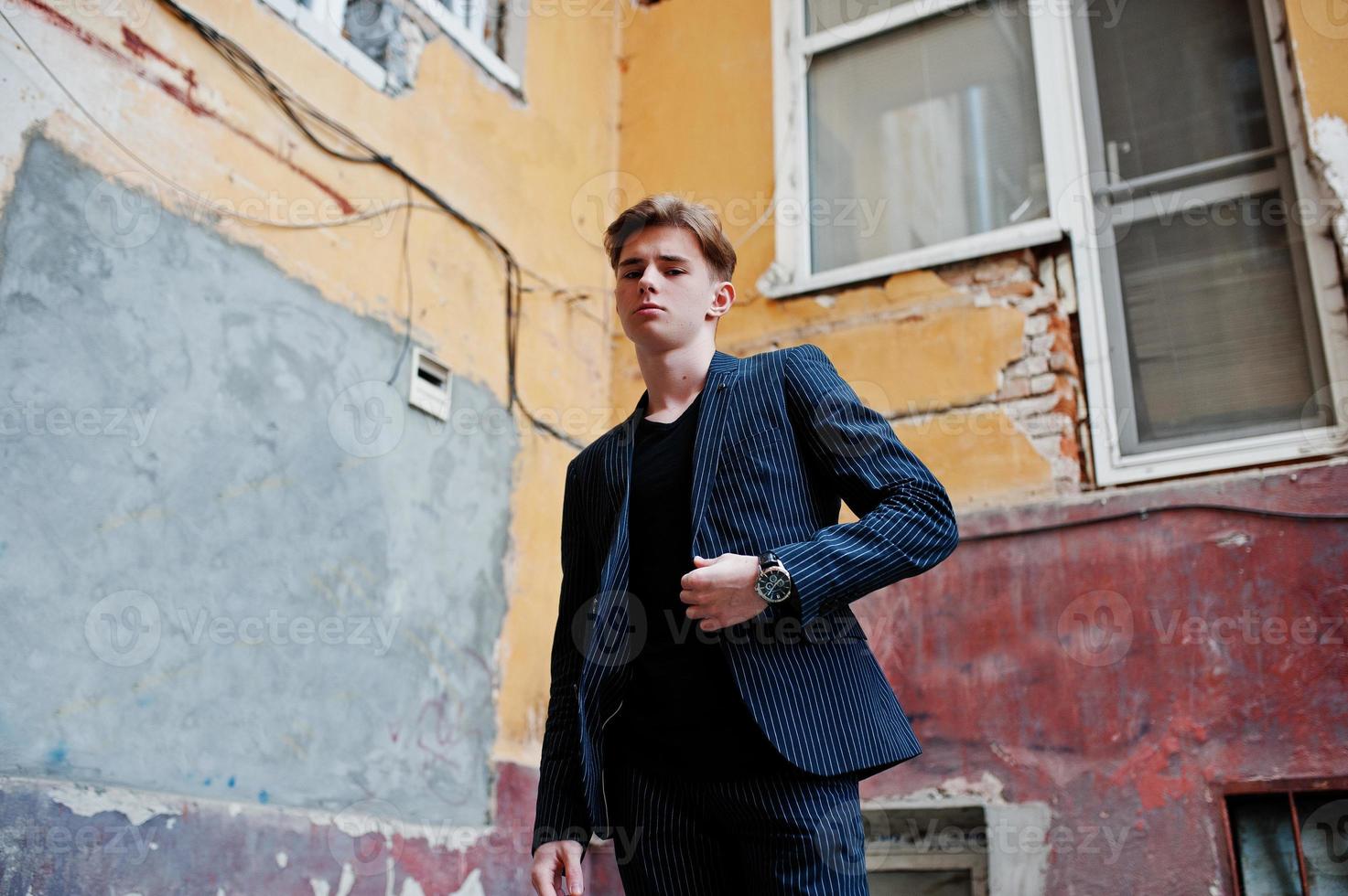 giovane ragazzo macho alla moda in giacca nera posato all'aperto di strada. fantastico uomo modello. foto