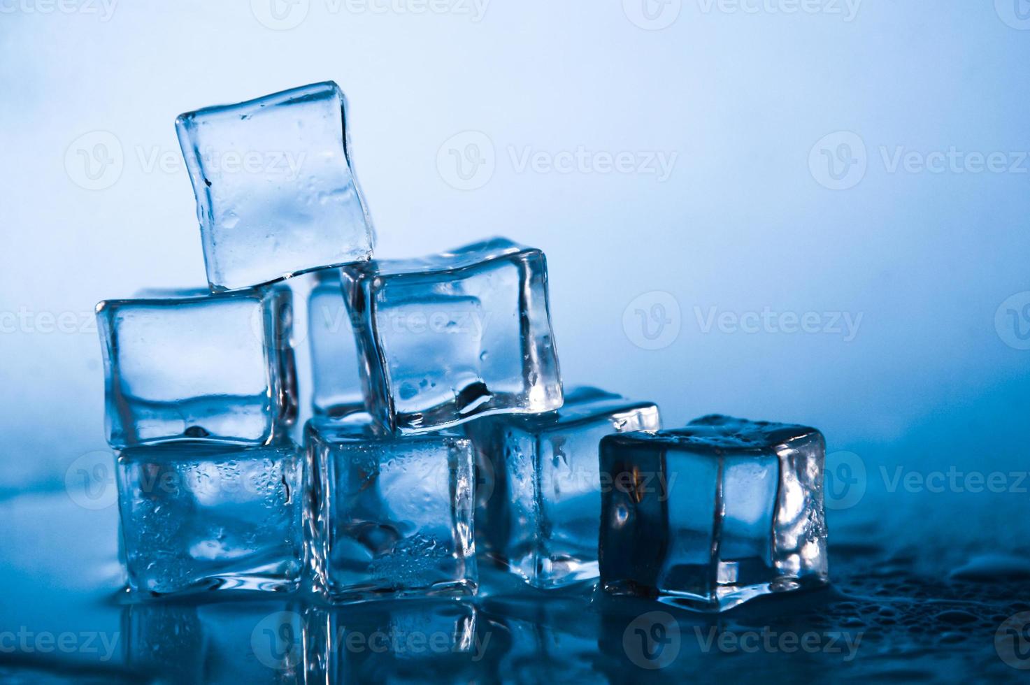 cubetti di ghiaccio su sfondo blu studio. il concetto di freschezza con la freschezza dei cubetti di ghiaccio. foto