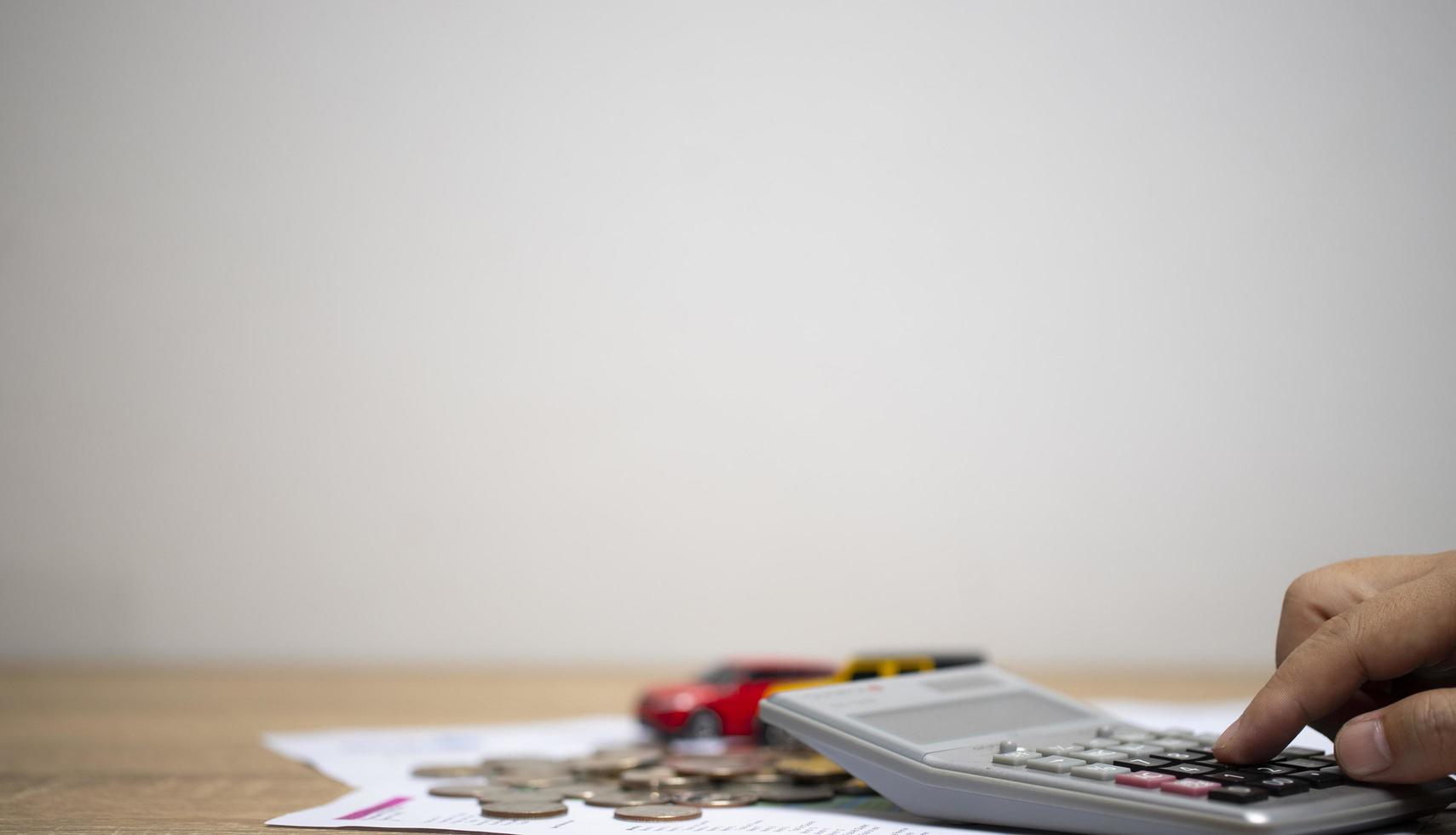 concetto di denaro e finanza per calcolare le entrate e le spese mucchio di monete su carta millimetrata sul tavolo. risparmiare soldi per comprare un'auto. foto