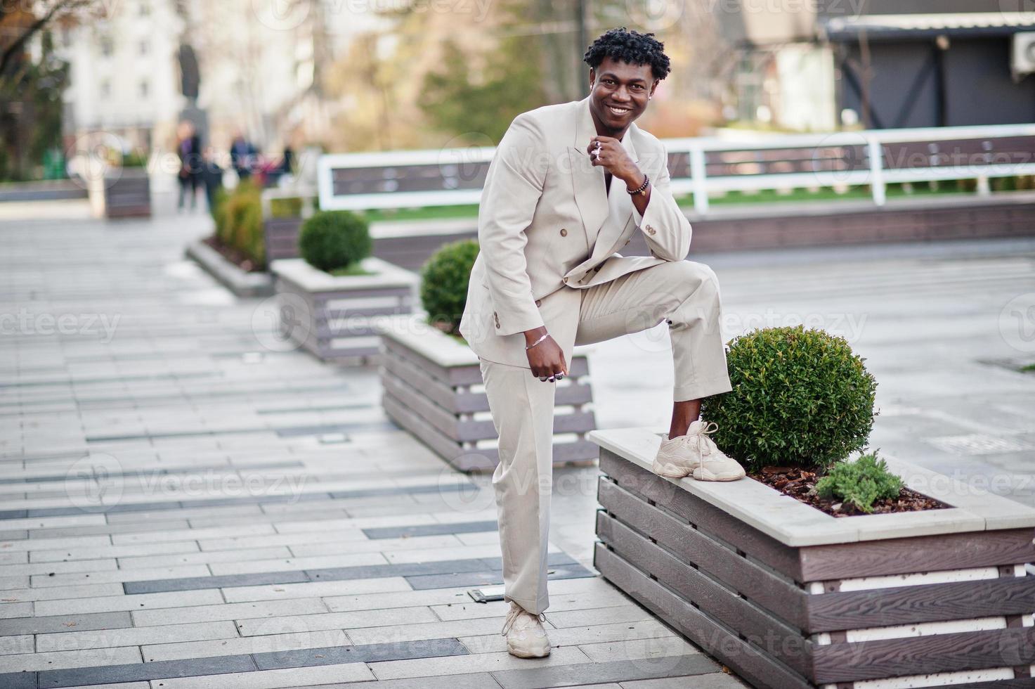 elegante uomo afro in abito beige vecchia scuola. giovane maschio africano alla moda in giacca casual sul torso nudo. foto