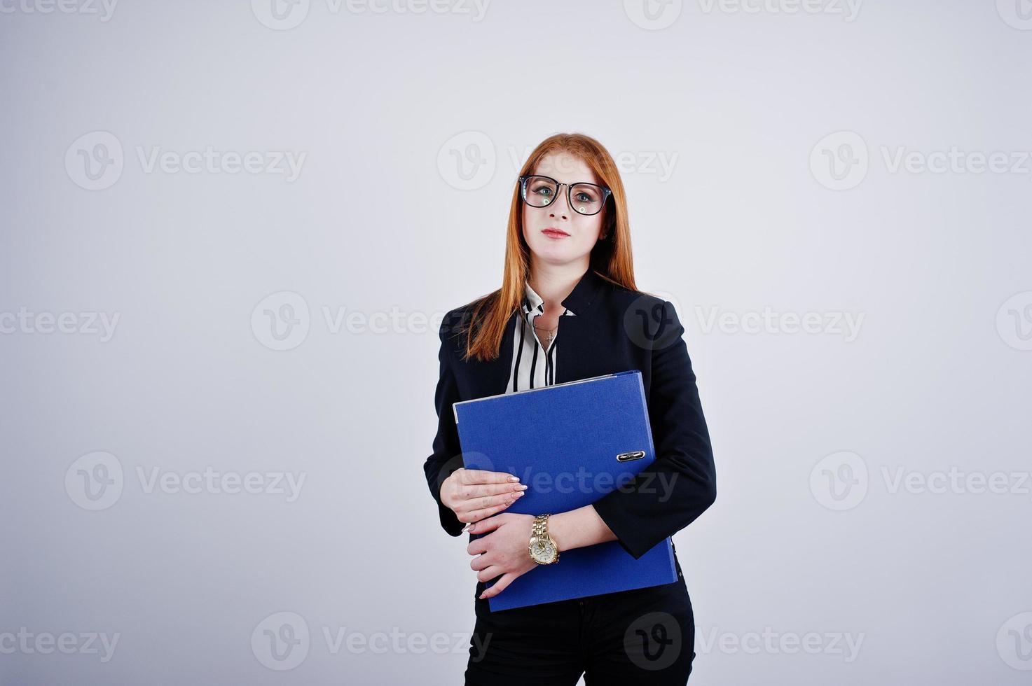 ritratto di una donna d'affari dai capelli rossi che indossa una camicetta a righe e una giacca con una cartella blu. foto