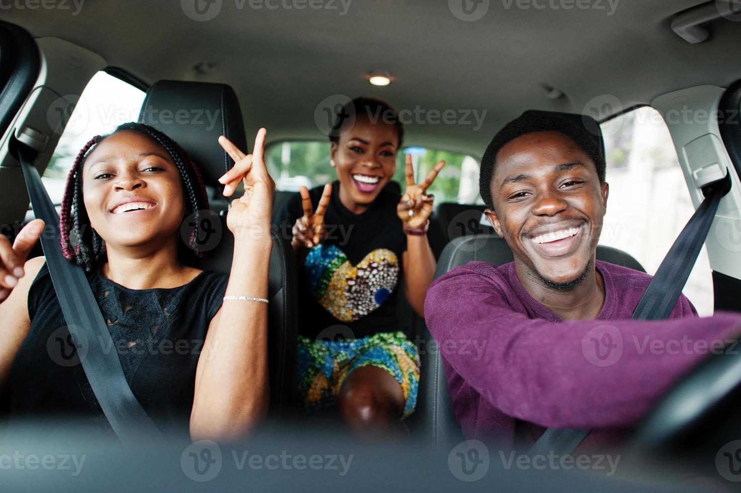 giovani amici afroamericani seduti all'interno di un'auto. foto