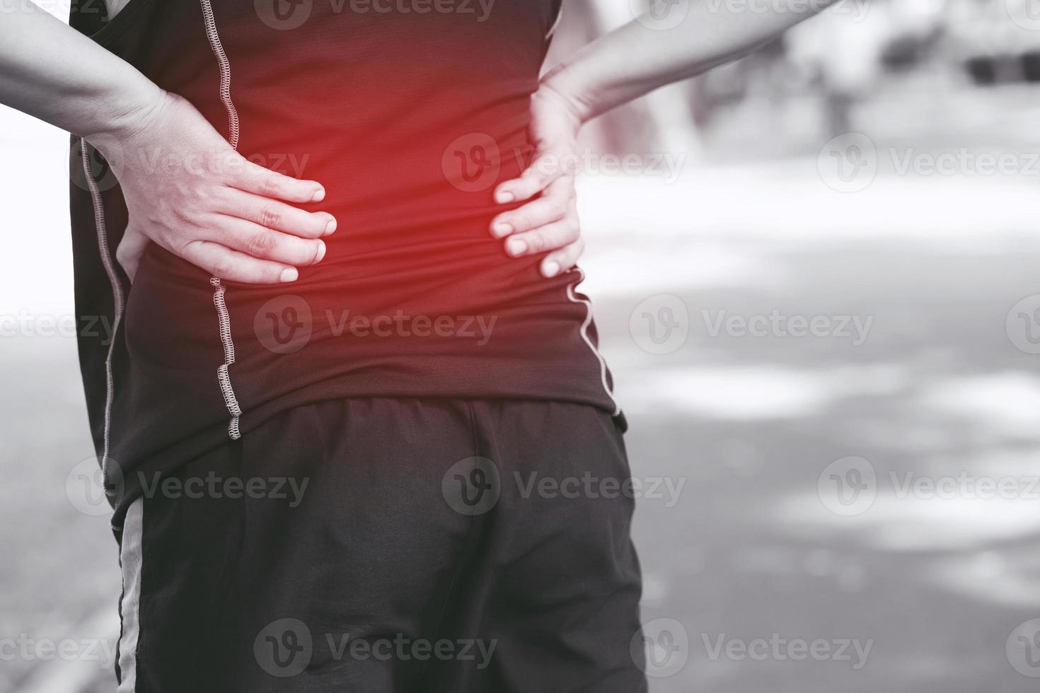 uomo infelice che soffre di lesioni sportive durante l'esercizio, con dolore lombare alla colonna vertebrale con mal di schiena. assistenza sanitaria delle persone o concetto medico. bianco e nero evidenziando il colore rosso che mostra dolore foto