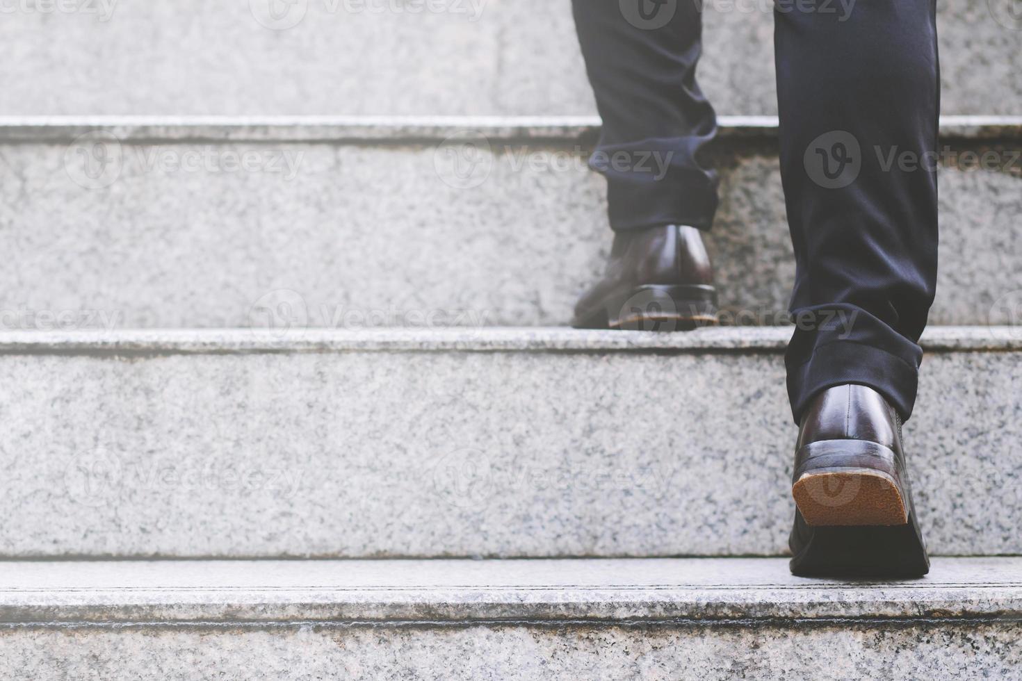 uomo d'affari moderno che lavora le gambe ravvicinate che salgono le scale nella città moderna. nell'ora di punta per lavorare in ufficio in fretta. durante la prima mattina di lavoro. scala foto