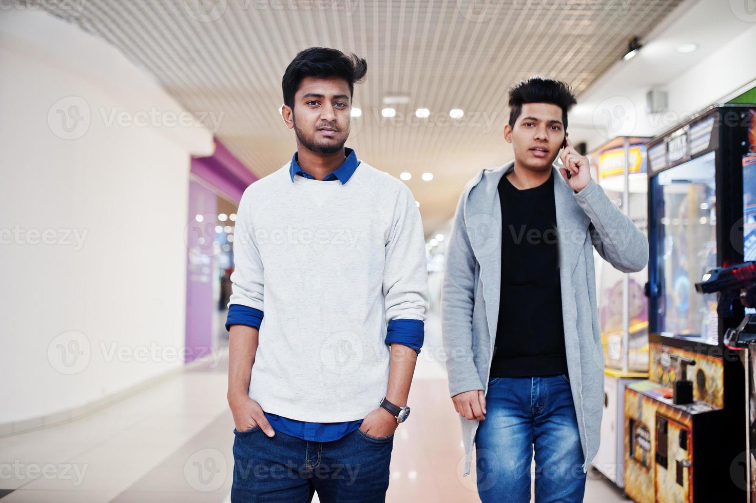 due ragazzi asiatici hanno posato nel parco giochi del simulatore. uno di loro parla al cellulare. foto