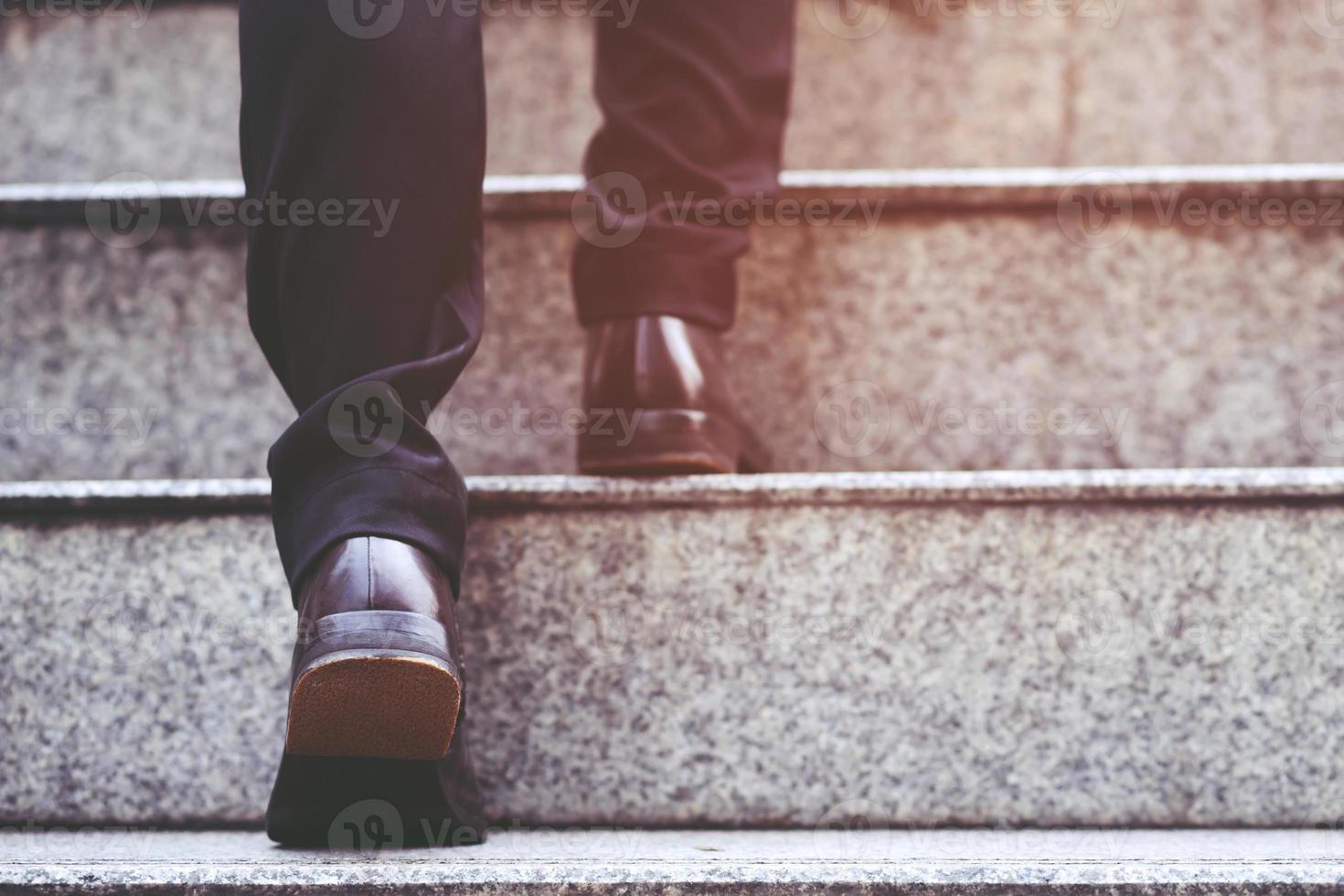 uomo d'affari moderno che lavora le gambe ravvicinate che salgono le scale nella città moderna. nell'ora di punta per lavorare in ufficio in fretta. durante la prima mattina di lavoro. scala. focalizzazione morbida foto