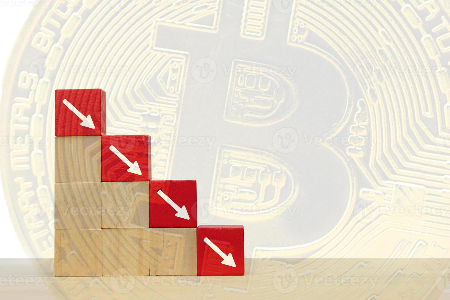 freccia rivolta verso il basso sul blocco di legno rosso. simbolo della caduta di bitcoin e criptovaluta su sfondo astratto foto