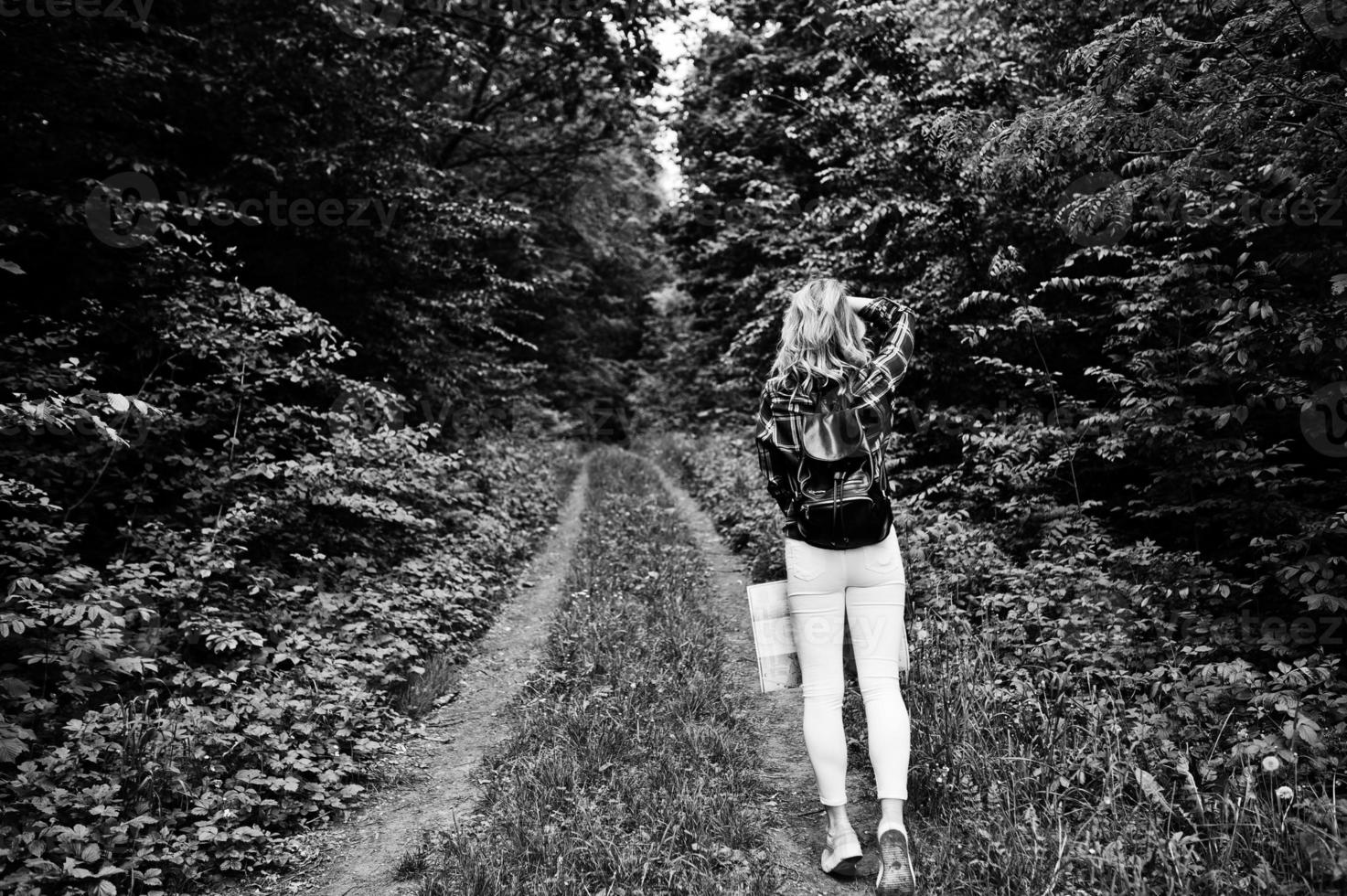 ritratto di una giovane e bella donna bionda in camicia scozzese in possesso di una mappa nella foresta. foto