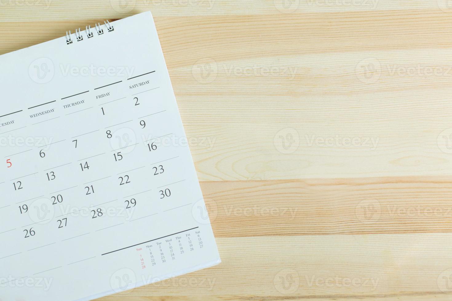 calendario sul tavolo in legno. spazio di copia vuoto per il testo. concetto per la sequenza temporale occupata organizzare il programma, l'appuntamento e il promemoria della riunione. pianificazione per riunioni di lavoro o concetto di pianificazione delle vacanze di viaggio. foto