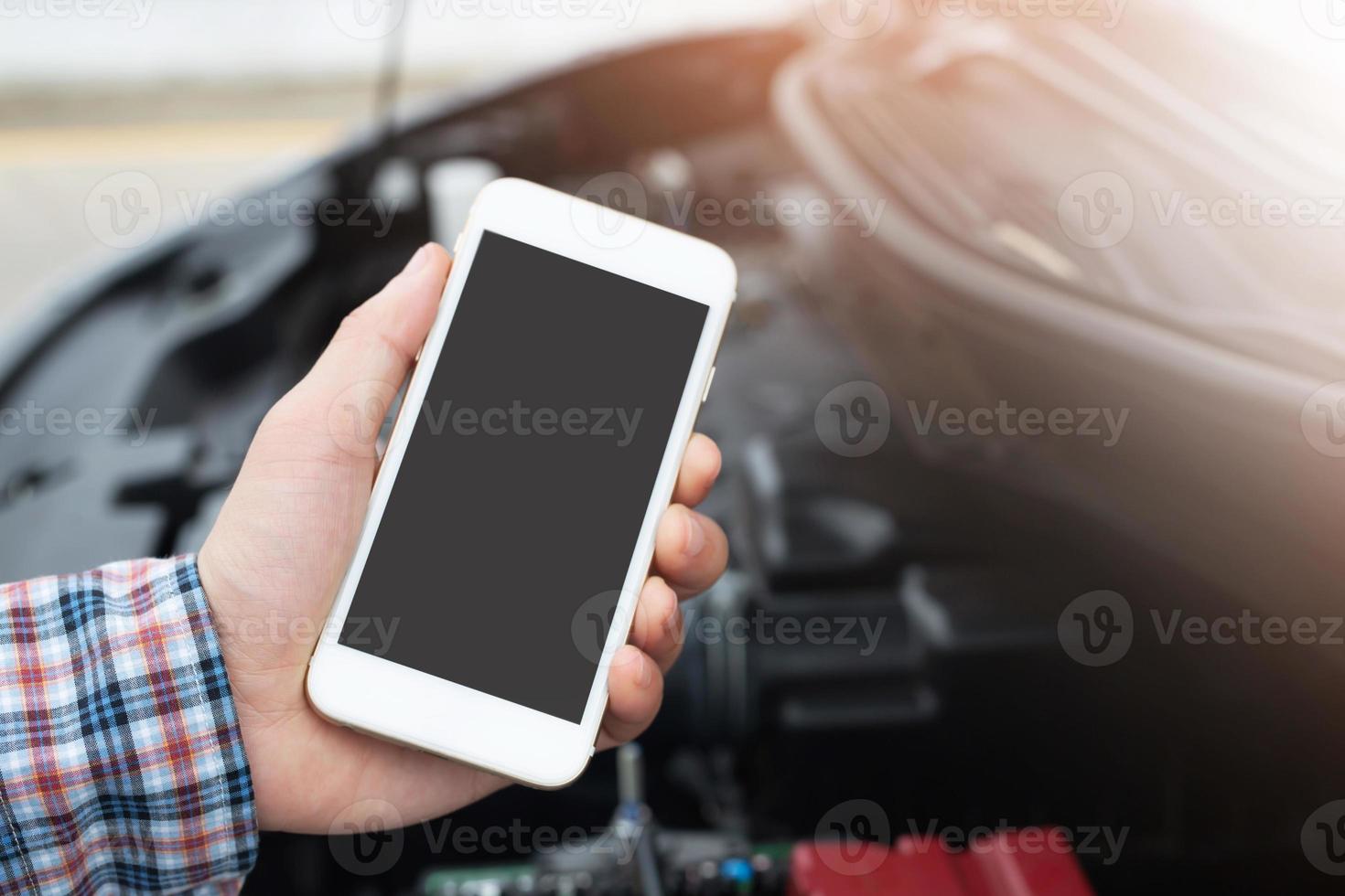 primo piano giovane uomo d'affari mano utilizzando uno smartphone cellulare chiamare un meccanico di auto chiedere aiuto assistenza perché l'auto si è rotta sul ciglio della strada. vuoto se schermo vuoto. foto