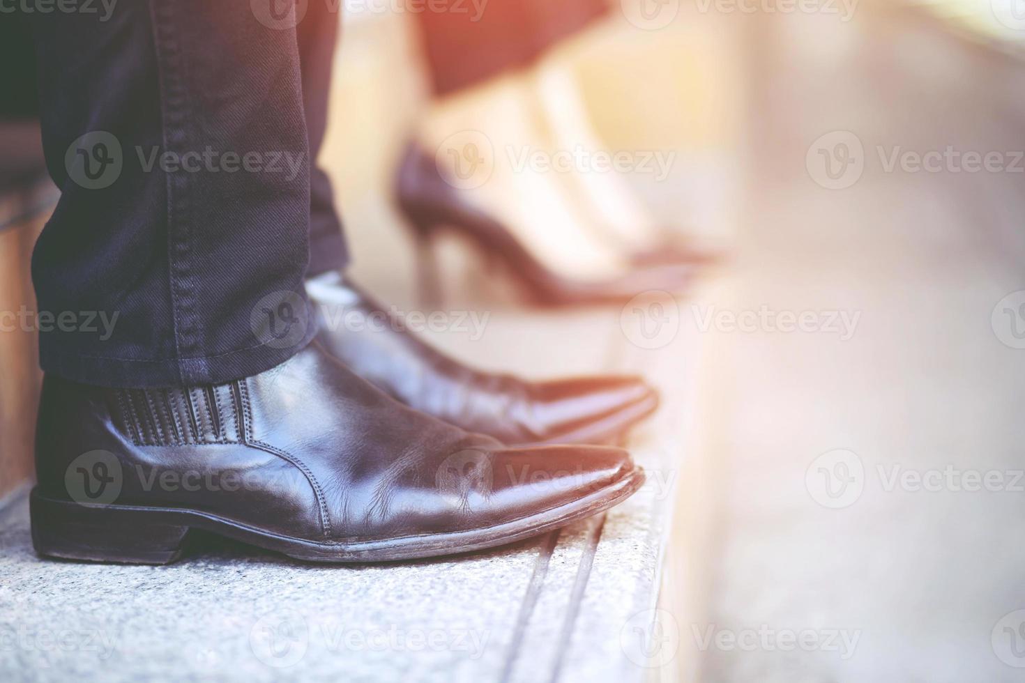 moderno uomo d'affari che lavora in primo piano gambe in piedi e cammina giù per le scale nella città moderna. nell'ora di punta per lavorare in ufficio in fretta. durante la prima mattina di lavoro. scala foto