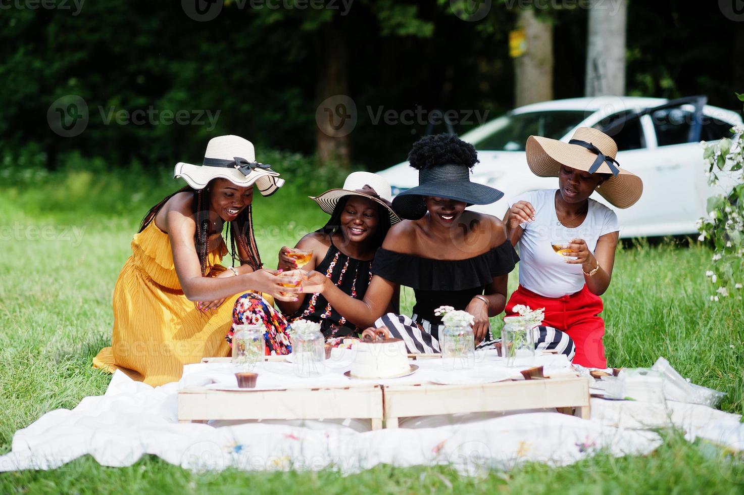 gruppo di ragazze afroamericane che celebrano la festa di compleanno e bicchieri tintinnanti all'aperto con decorazioni. foto