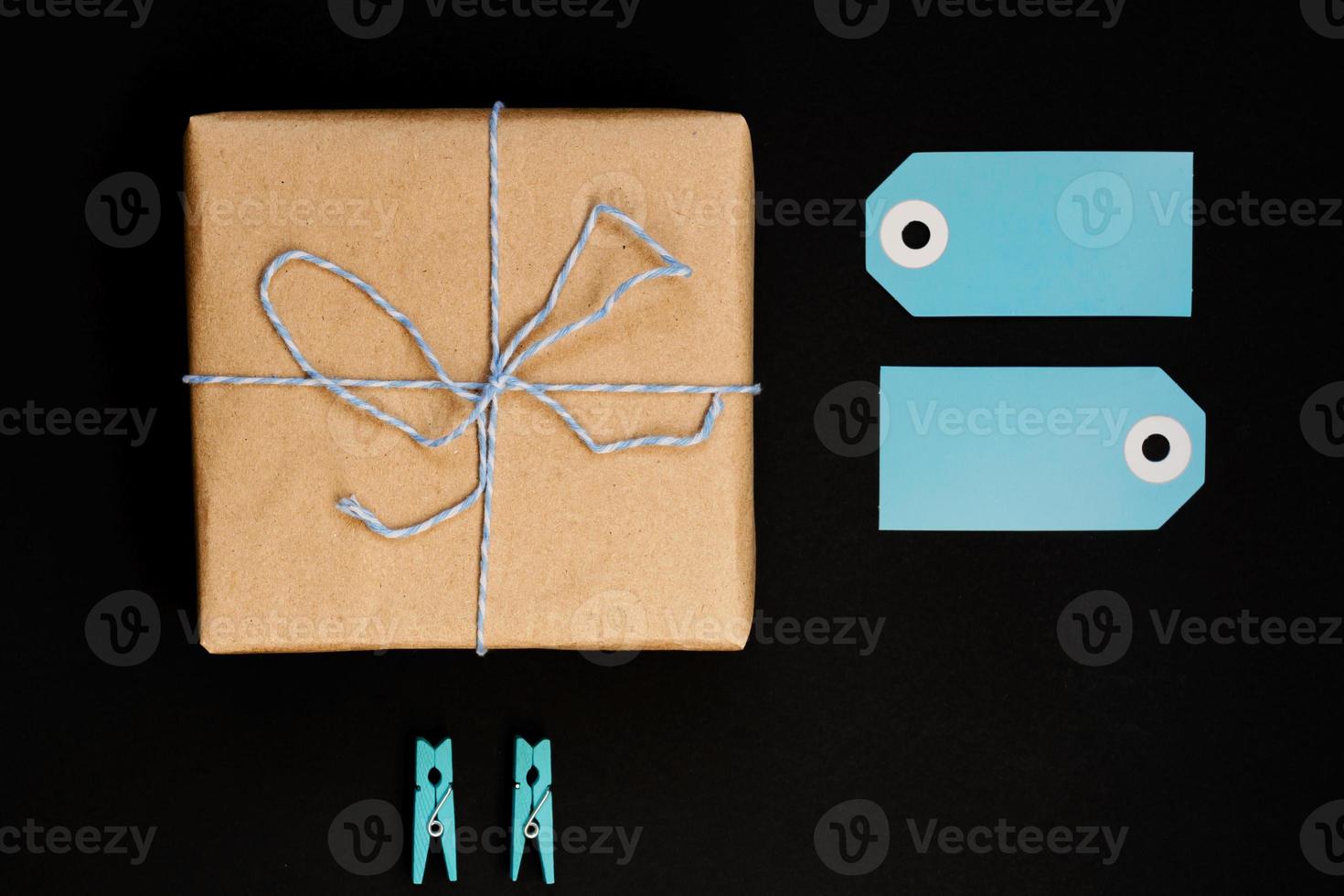 scatole regalo artigianali avvolte in carta artigianale con cartellino in carta blu, corda e mollette in legno per la decorazione. foto