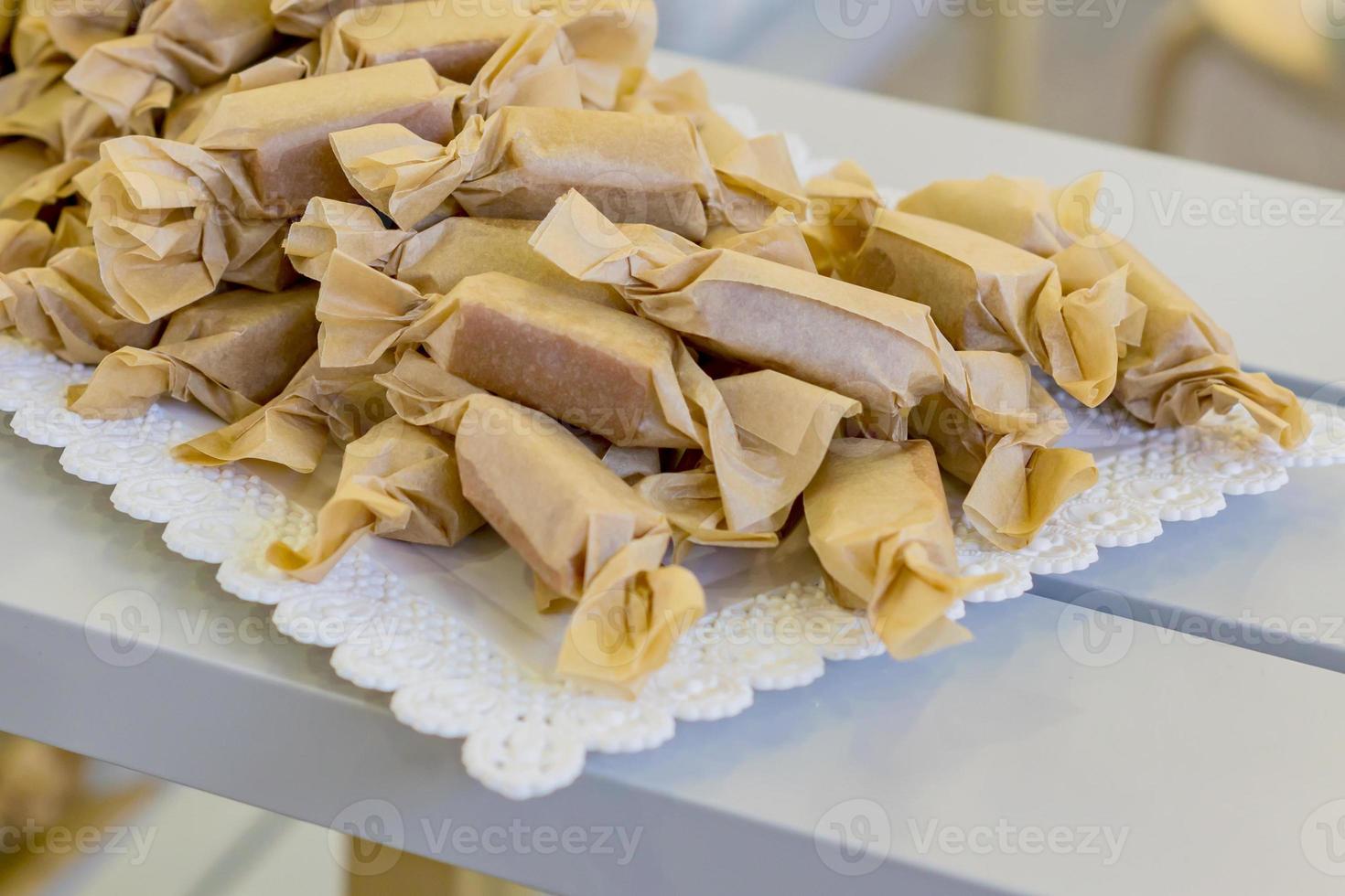 primo piano di caramelle fatte a mano avvolte in carta artigianale. foto