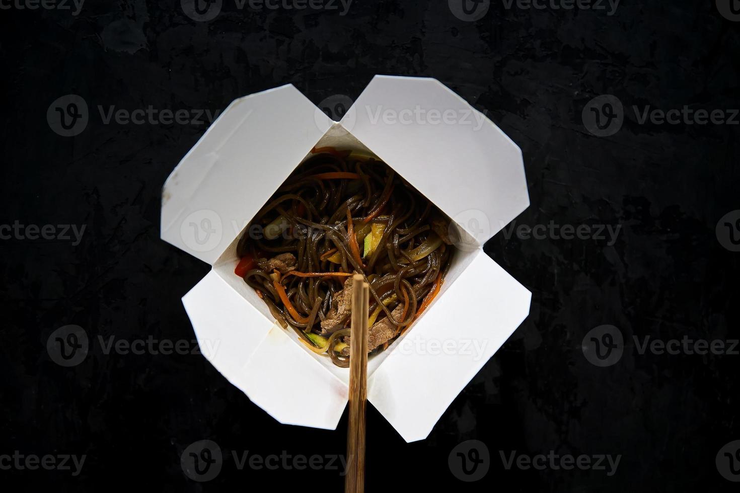 fast food asiatico in una scatola. udon con verdure e manzo foto