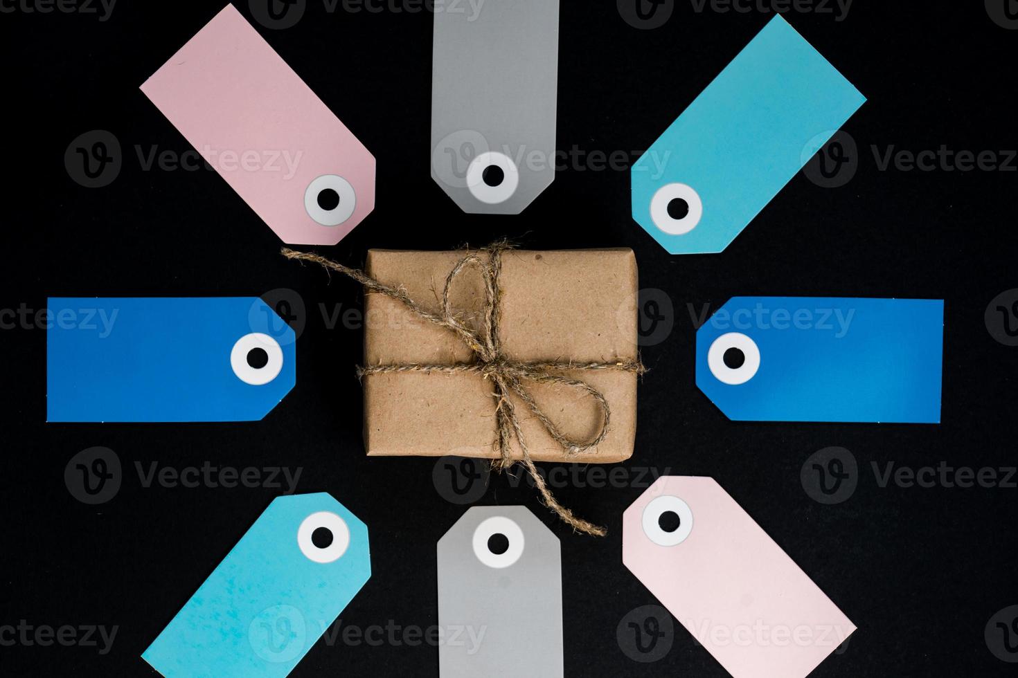 confezione regalo artigianale avvolta in carta artigianale con etichette di carta di carta vlue, rosa e grigia intorno foto