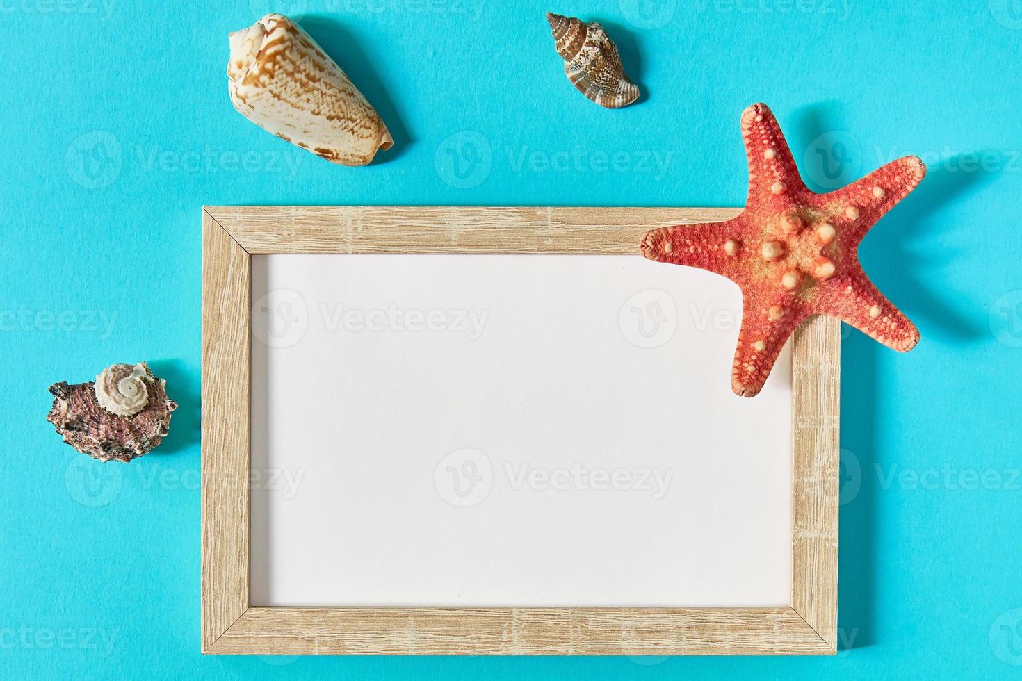 mockup photoframe con conchiglie e stelle marine su sfondo blu. concetto marino e di vacanza foto