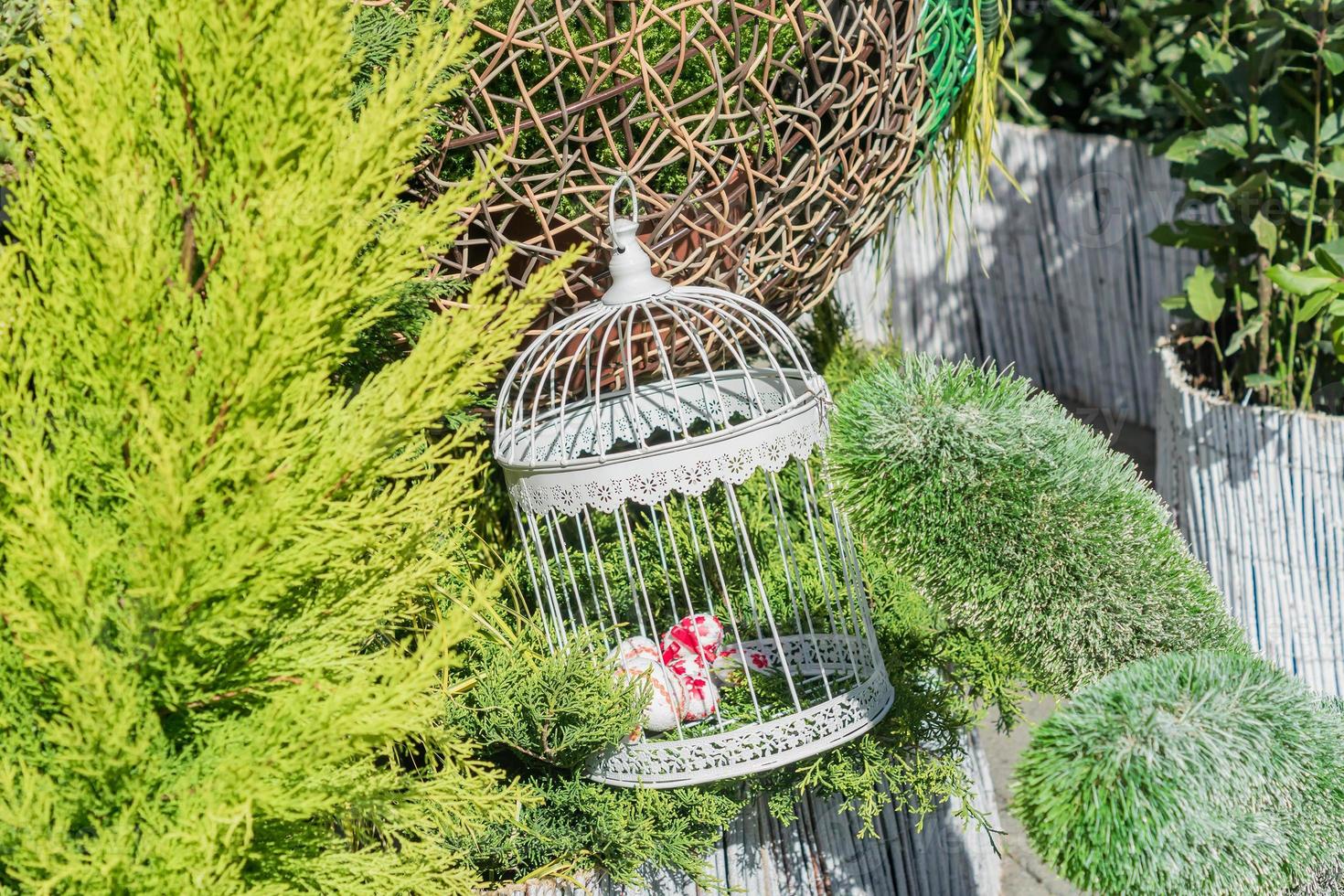 uova di Pasqua in una gabbia per uccelli decorativa bianca. decorazione all'aperto. foto