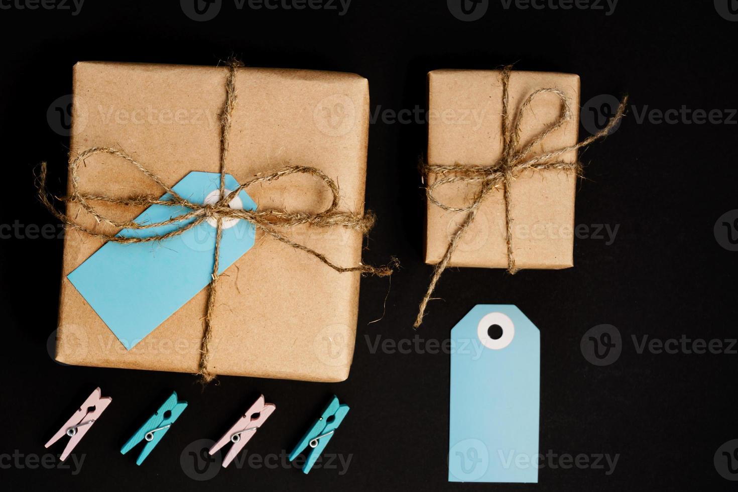 scatole regalo artigianali avvolte in carta artigianale con cartellino in carta blu, corda e mollette in legno per la decorazione. foto