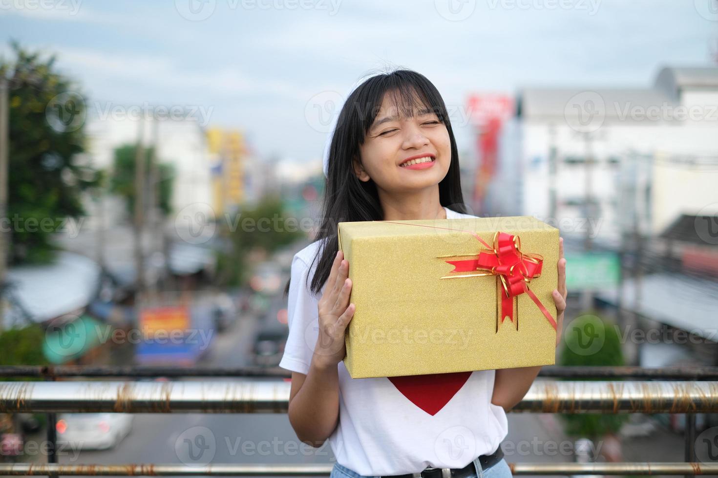contento giovane ragazza con regalo scatola. foto