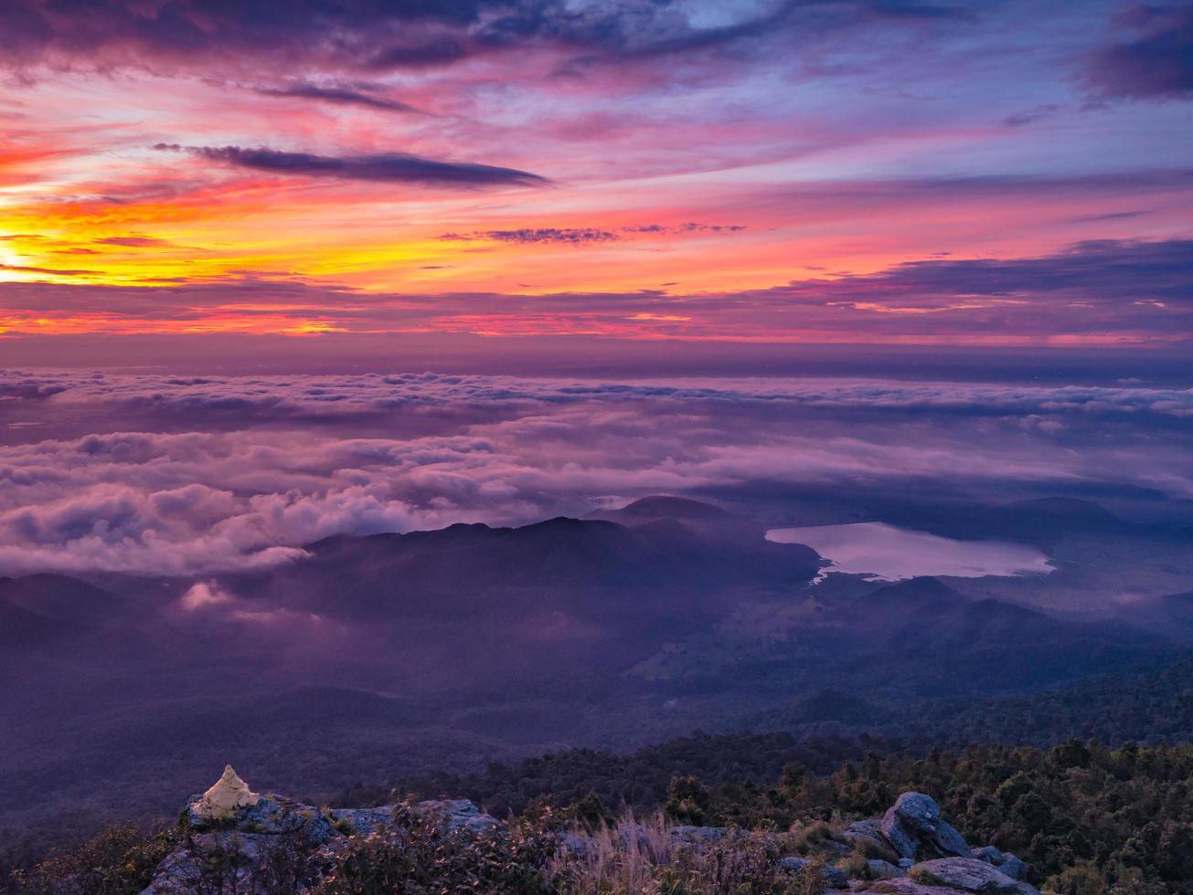 bellissimo Alba cielo con mare di il nebbia di nebbia e piccolo d'oro pagoda nel il mattina su khao luang montagna nel ramkhamhaeng nazionale parco, sukhothai Provincia Tailandia foto