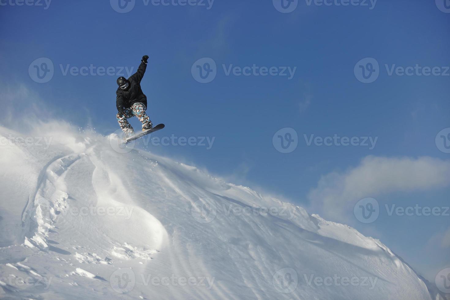 lo snowboarder freestyle salta e cavalca foto