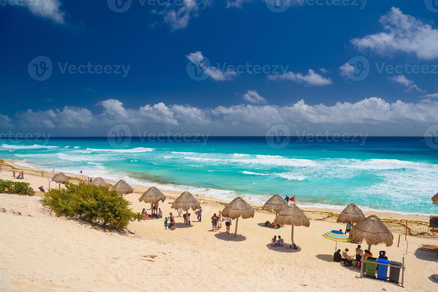 ombrelloni su una spiaggia sabbiosa con acqua azzurra in una giornata di sole vicino a cancun, in messico foto