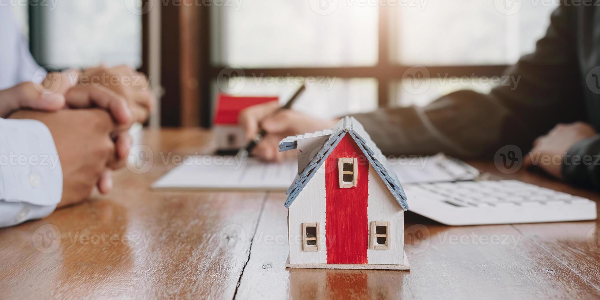 miniatura di Villetta Casa su tavolo vicino su Visualizza, contento africano famiglia, agenzia o banca clienti stretta di mano vero tenuta agente dopo contrarre firma, su sfocato sfondo. foto