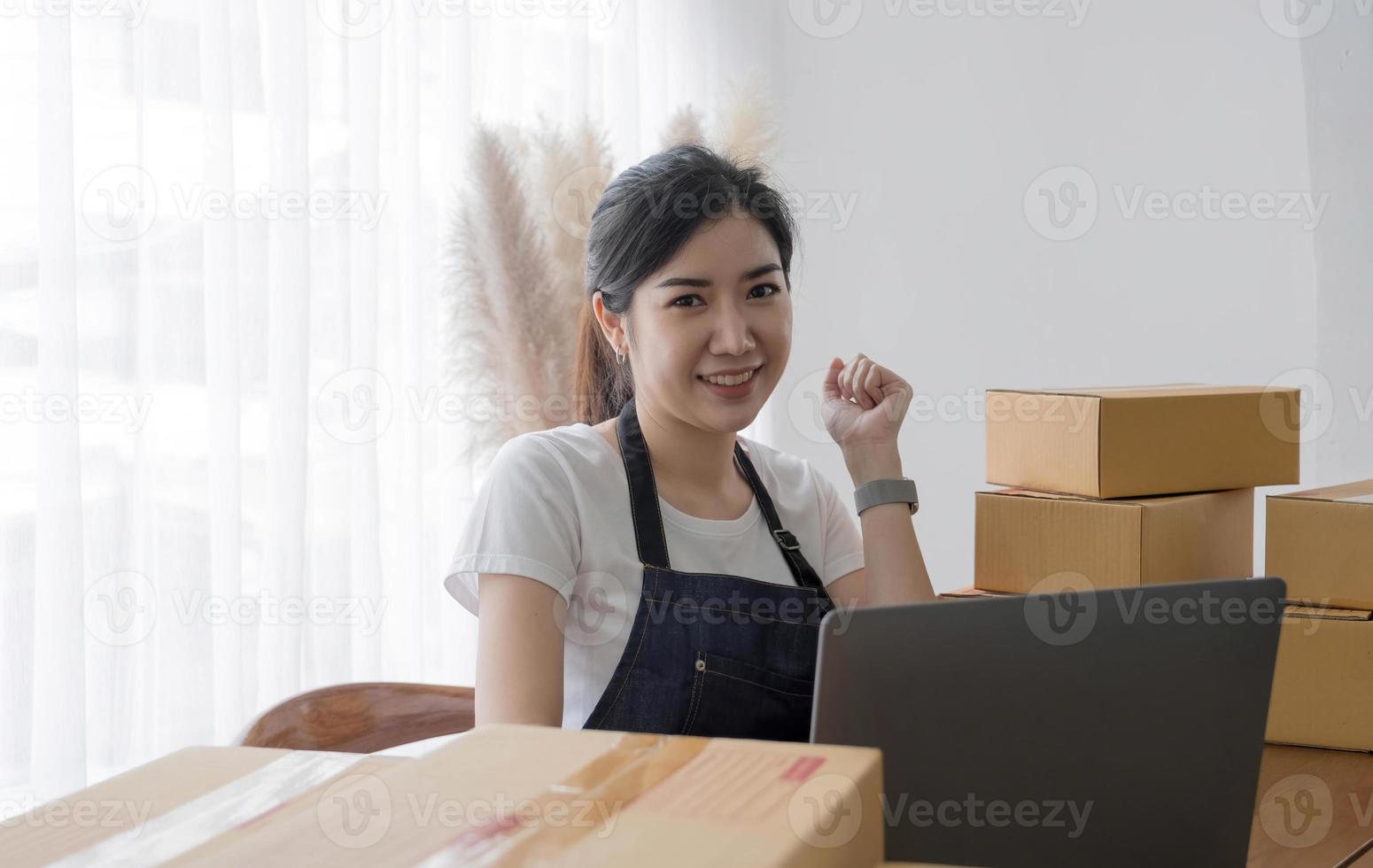 ritratto di giovane donna asiatica sme che lavora con una scatola a casa sul posto di lavoro. proprietario di una piccola impresa di start-up, PMI imprenditore di piccole imprese o business freelance online e concetto di consegna. foto