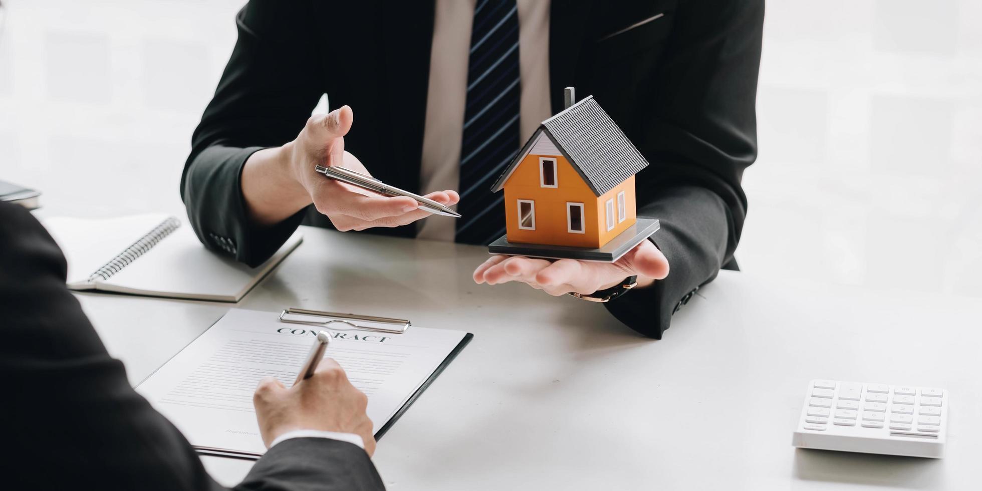 agente di intermediazione immobiliare che presenta e consulta il cliente per prendere decisioni firmare un contratto di assicurazione, acquistare e vendere modello di casa, riguardante l'offerta di mutuo ipotecario e l'assicurazione sulla casa foto