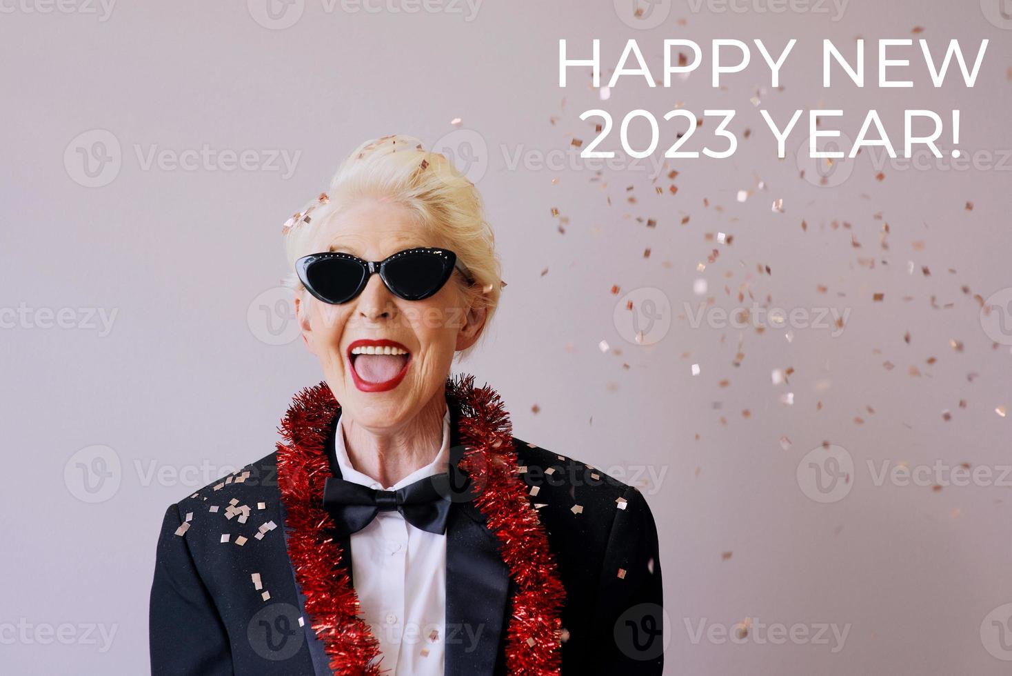bella ed elegante donna anziana matura in occhiali da sole e smoking per celebrare il nuovo anno. divertimento, festa, stile, concetto di celebrazione foto